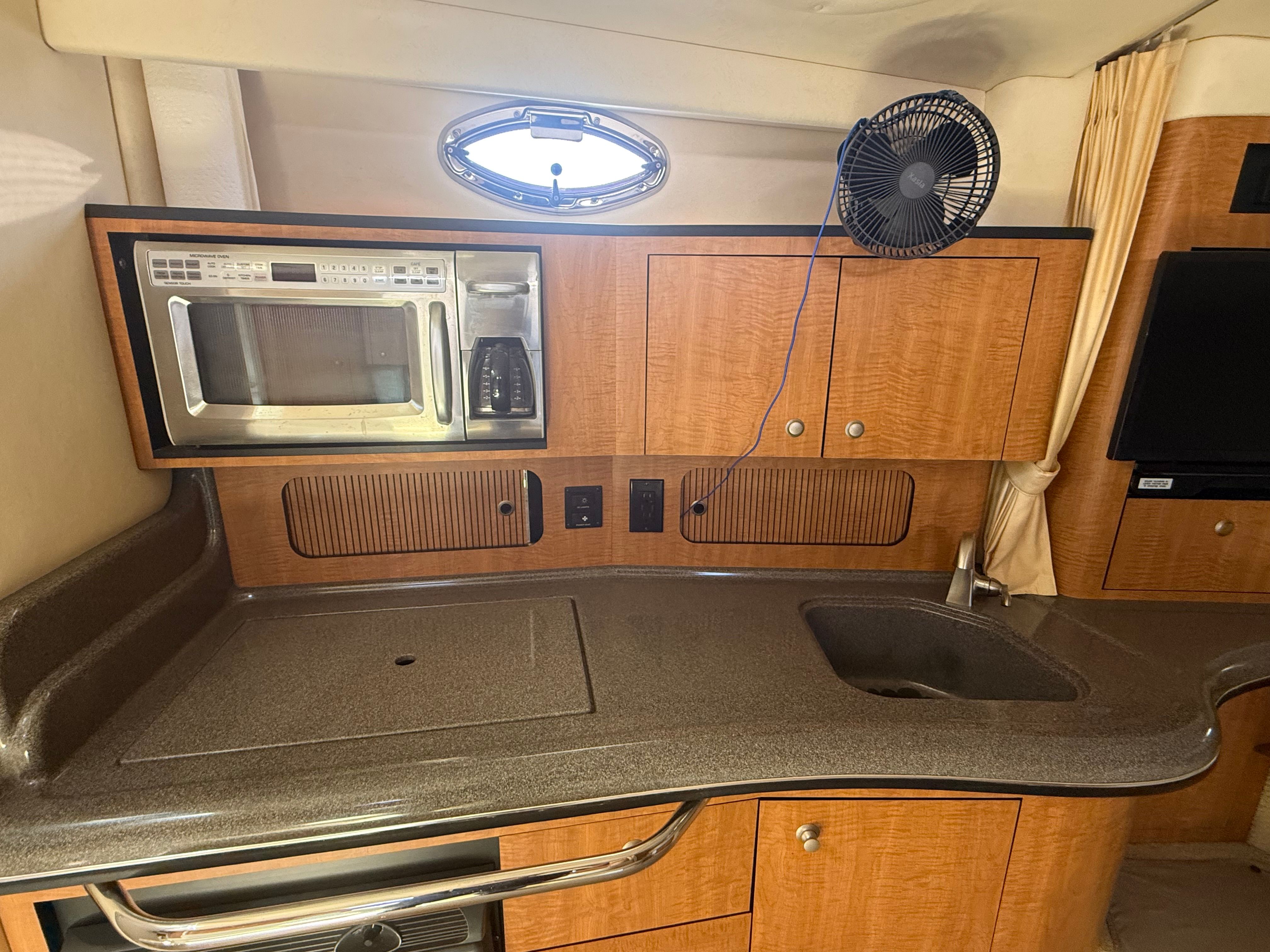 Interior of a 2006 Sea Ray Sundancer 320 with kitchenette and microwave.