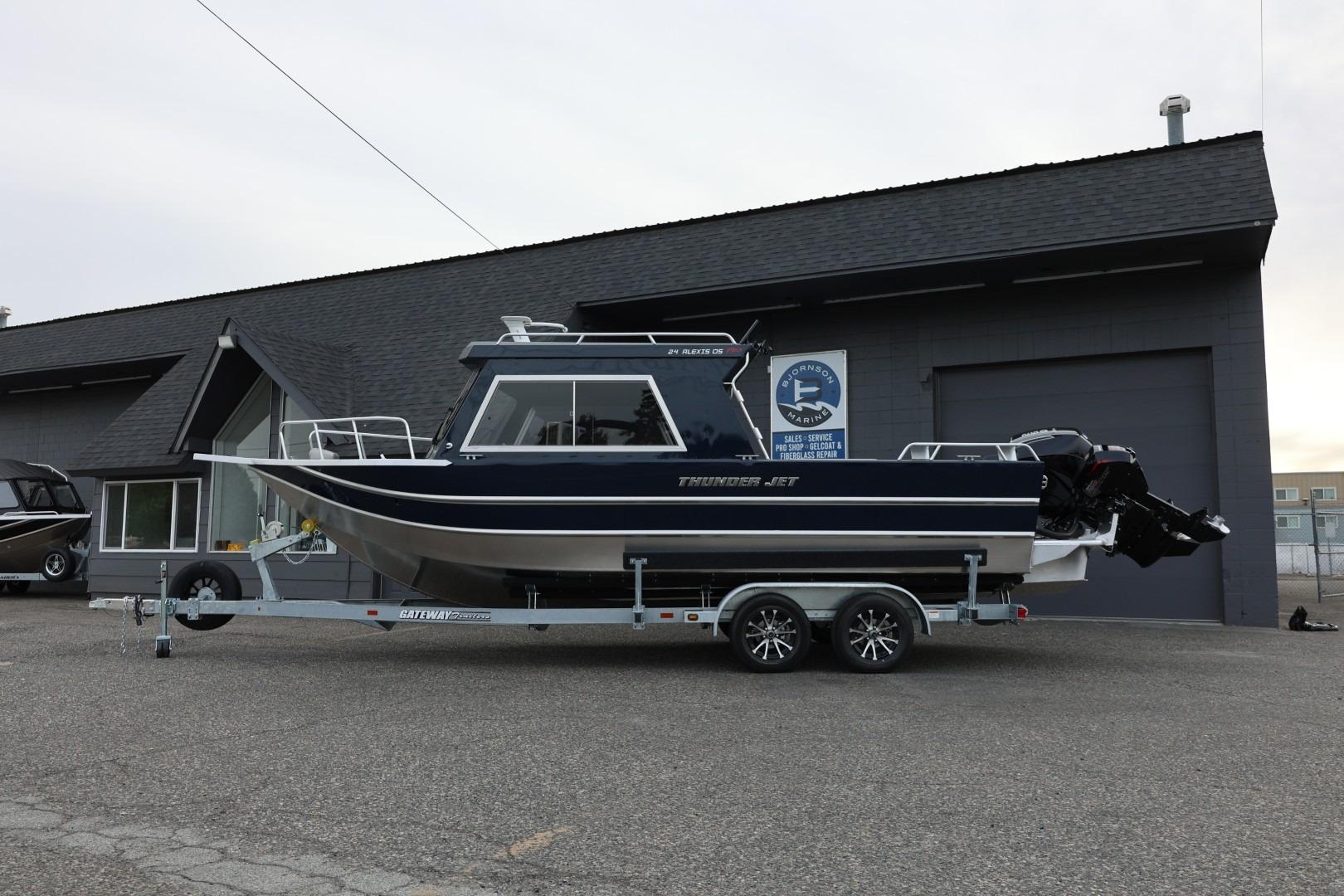 2026 Thunder Jet 24 Alexis Pro boat on trailer outside a marine dealership.