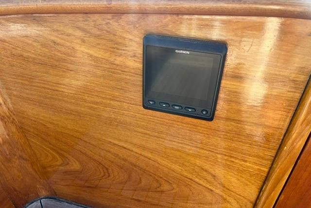 Garmin device mounted on wooden panel of 2006 Morris 36 boat interior.