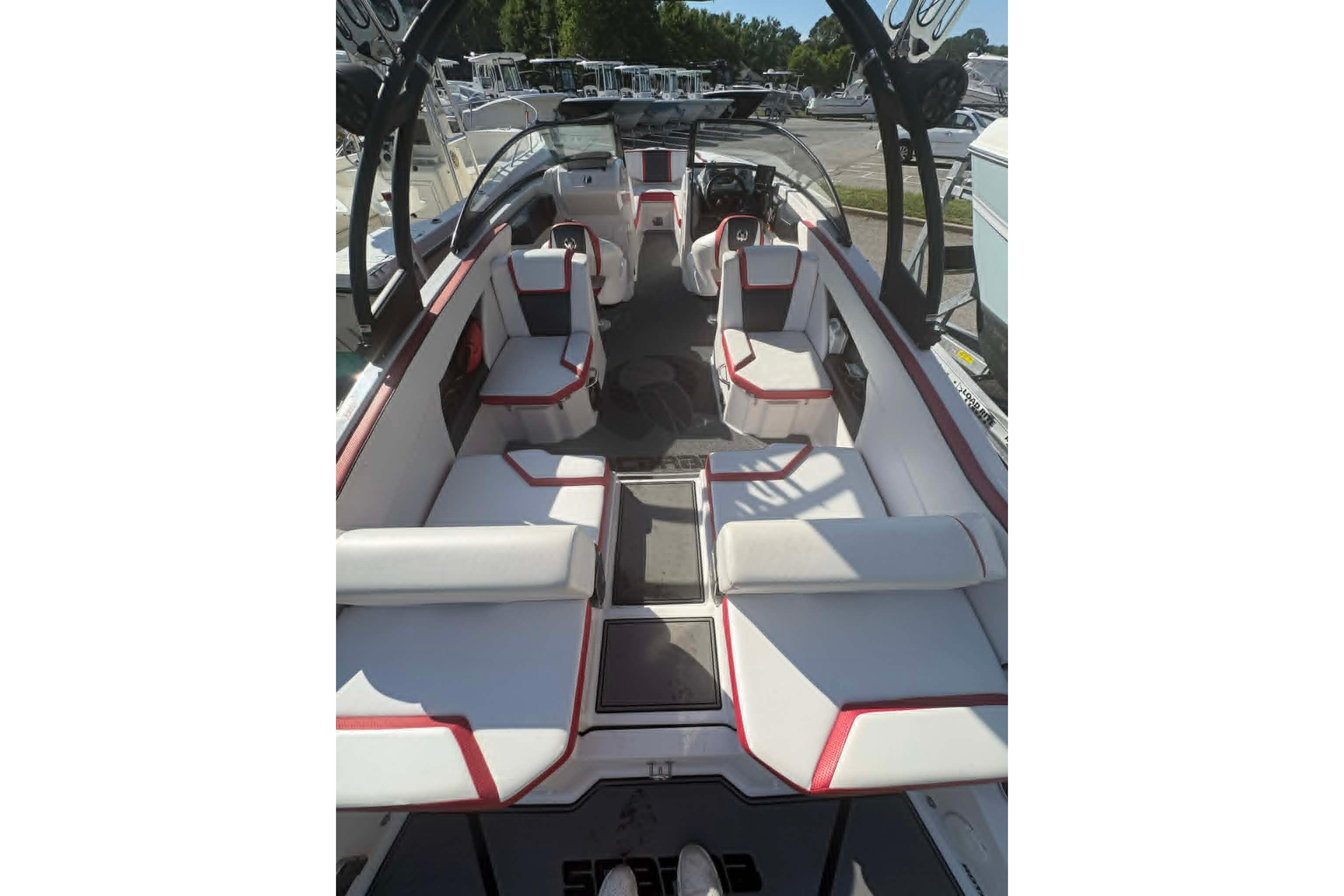2016 Scarab 255 H.O. Impulse boat interior with white and red seating, docked outdoors.