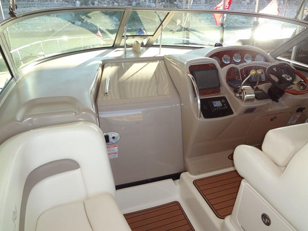 2005 Sea Ray 320 Sundancer cockpit with beige seating and wood accents.