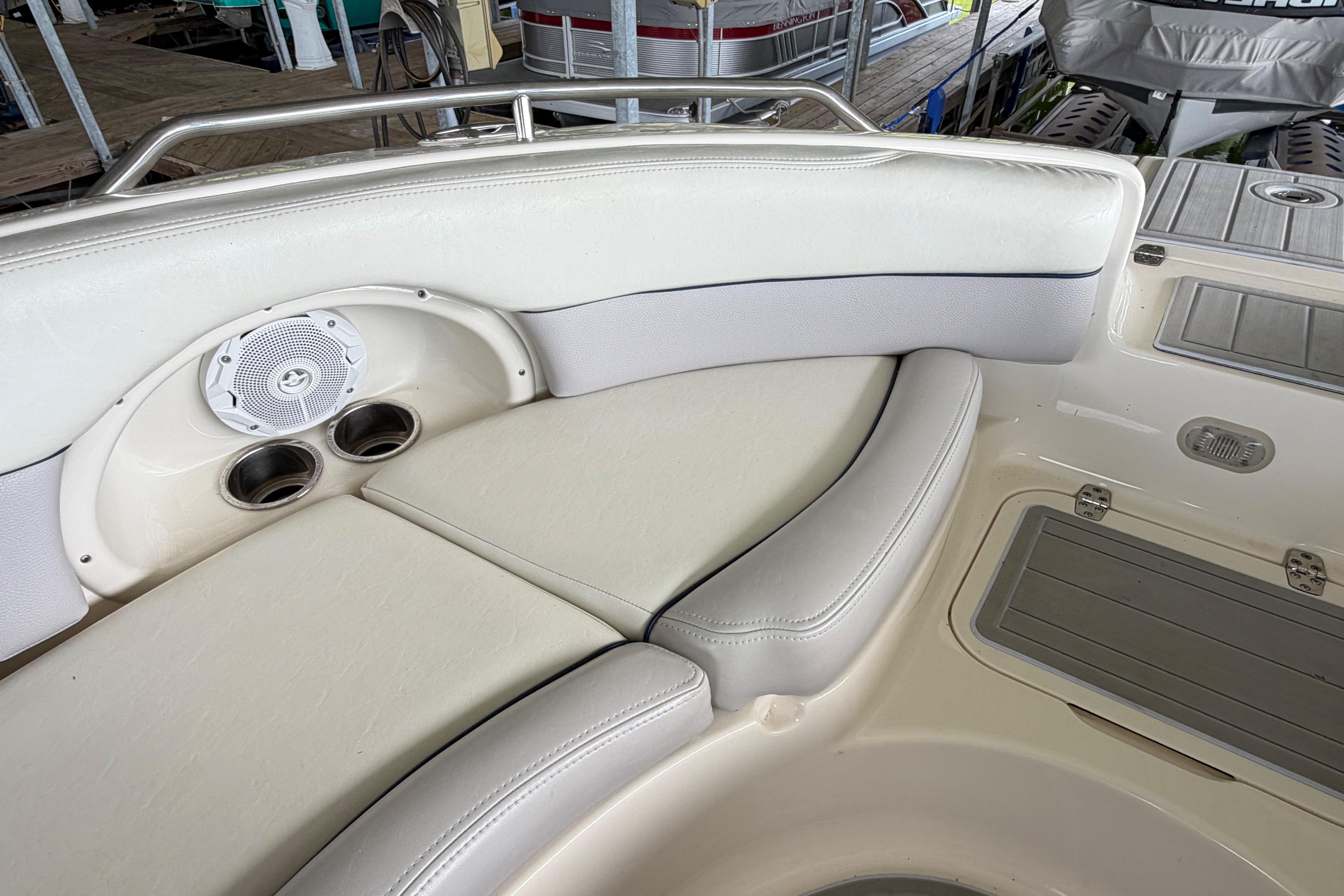 Interior of a 2010 Bryant 255 boat with cushioned seating and built-in speaker.