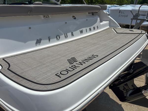 2023 Four Winns H1 boat with branded swim platform in sunlight.