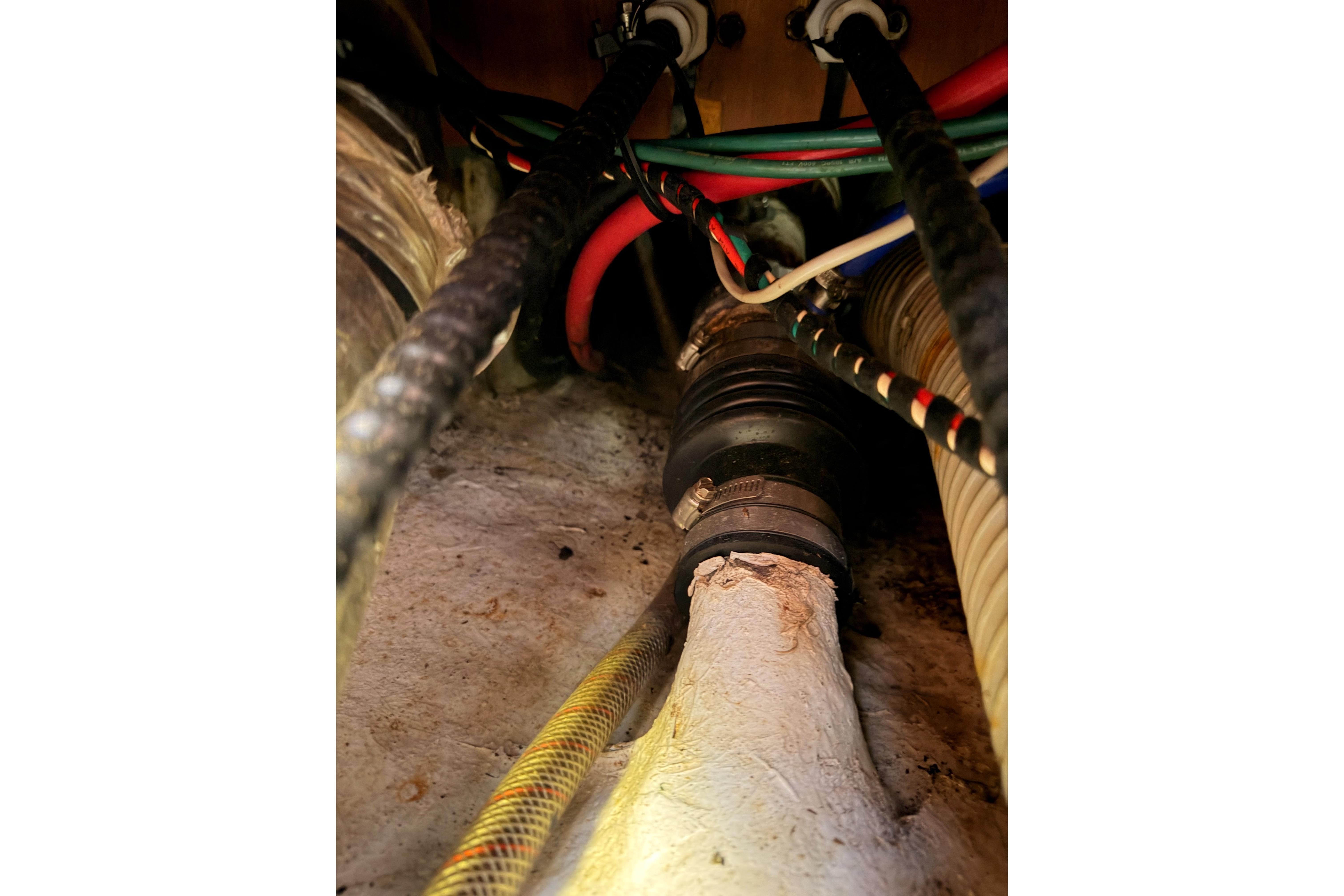 Wiring and hoses inside a 1991 Hylas 51 yacht, showcasing complex marine engineering.