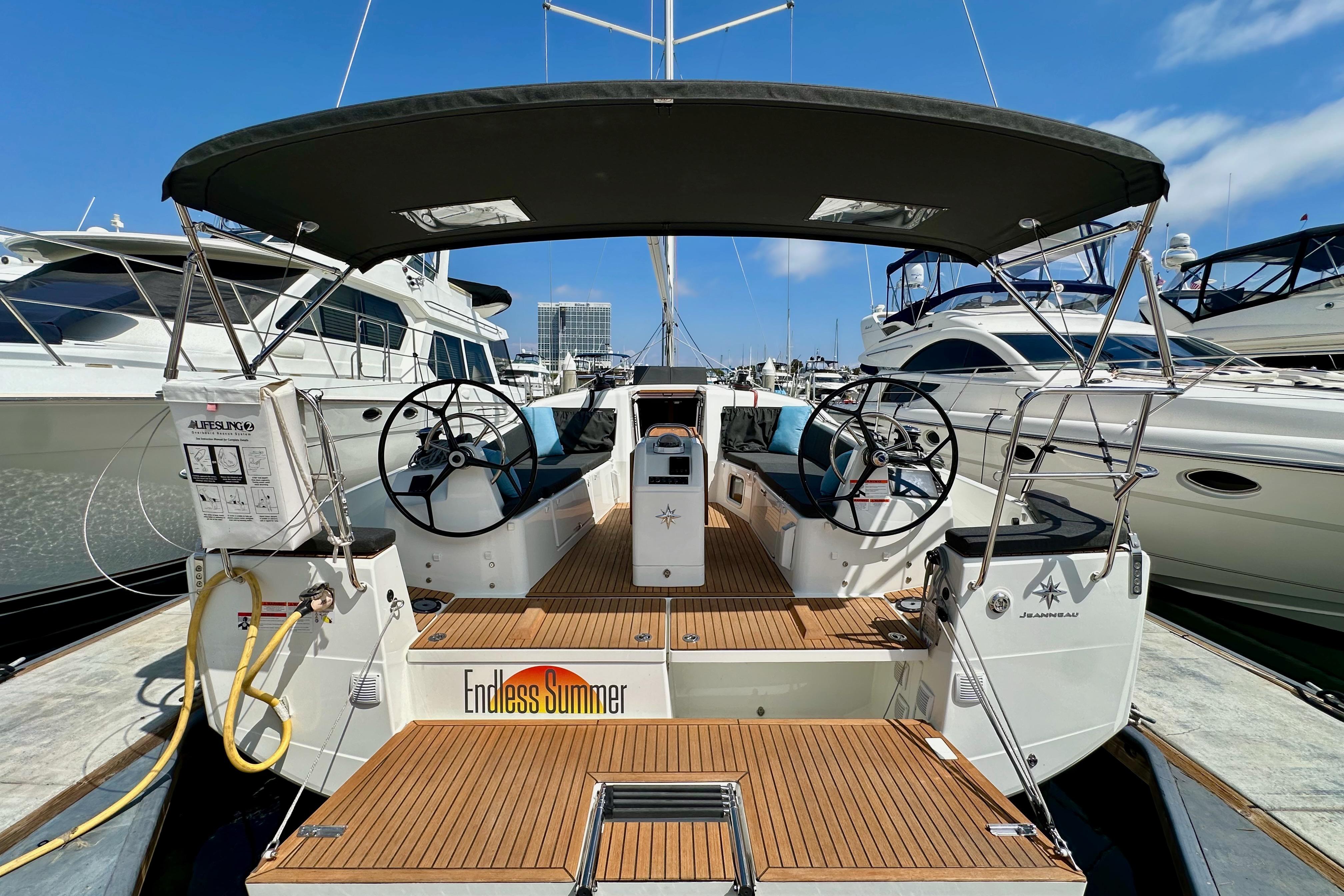 2024 Jeanneau Sun Odyssey 410 sailboat with dual steering wheels, docked at a marina.