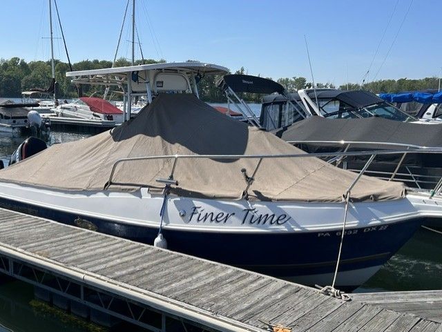 2000 Aquasport Osprey 250 docked at a marina.