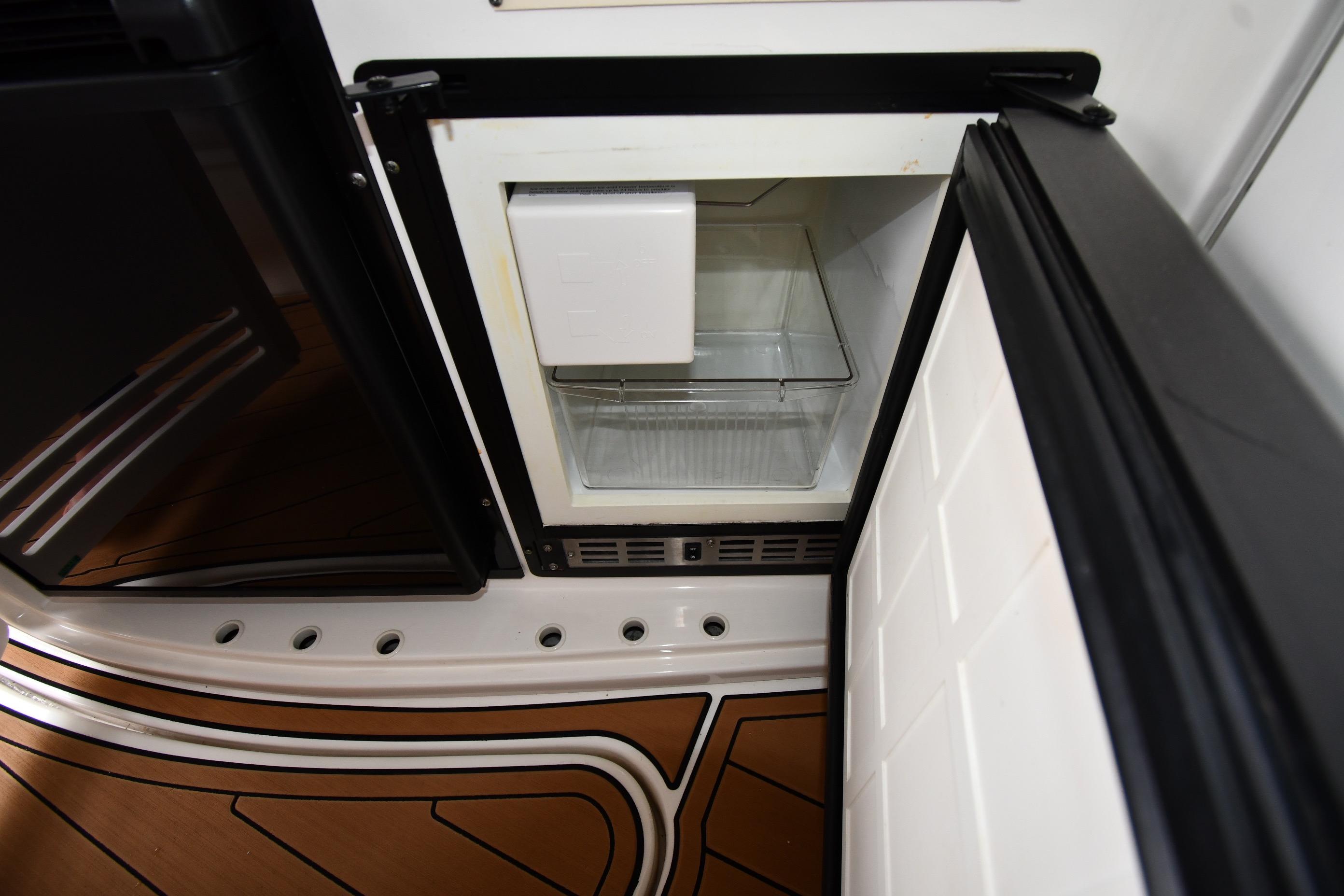 Open refrigerator on 2001 Sea Ray 540 Sundancer yacht, showcasing interior storage space.