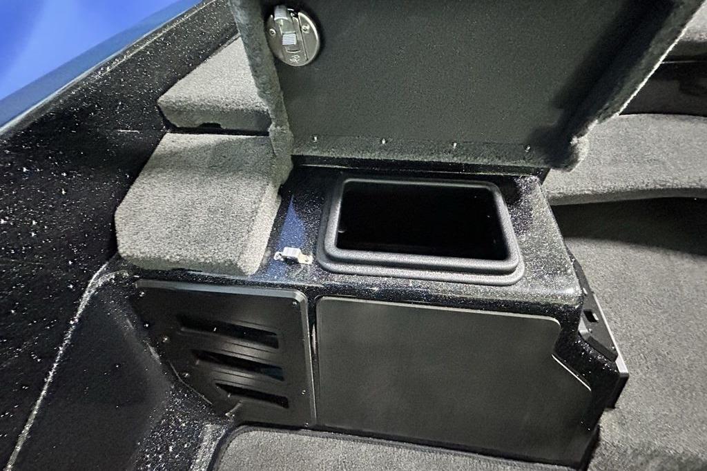 Interior storage compartment of 2026 Skeeter ZX200 boat, featuring carpeted surfaces and secure latch.
