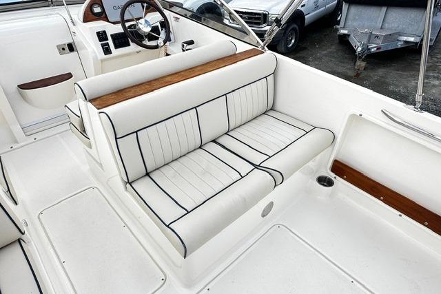 2022 Rossiter R23 Picnic Boat interior with white seating and wood accents.