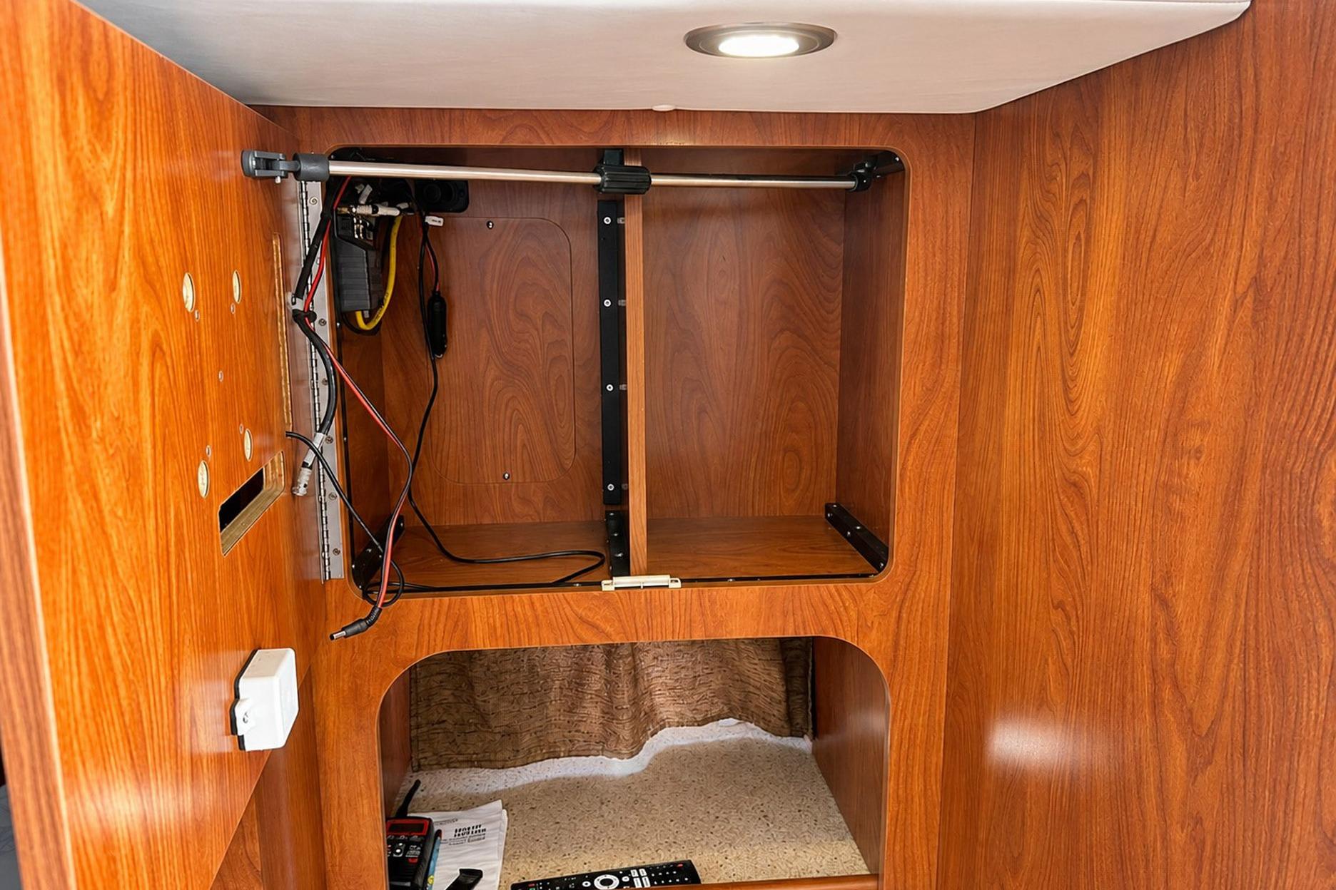 Interior of 2012 Rinker 310 Express Cruiser LE with wooden cabinetry and wiring setup.