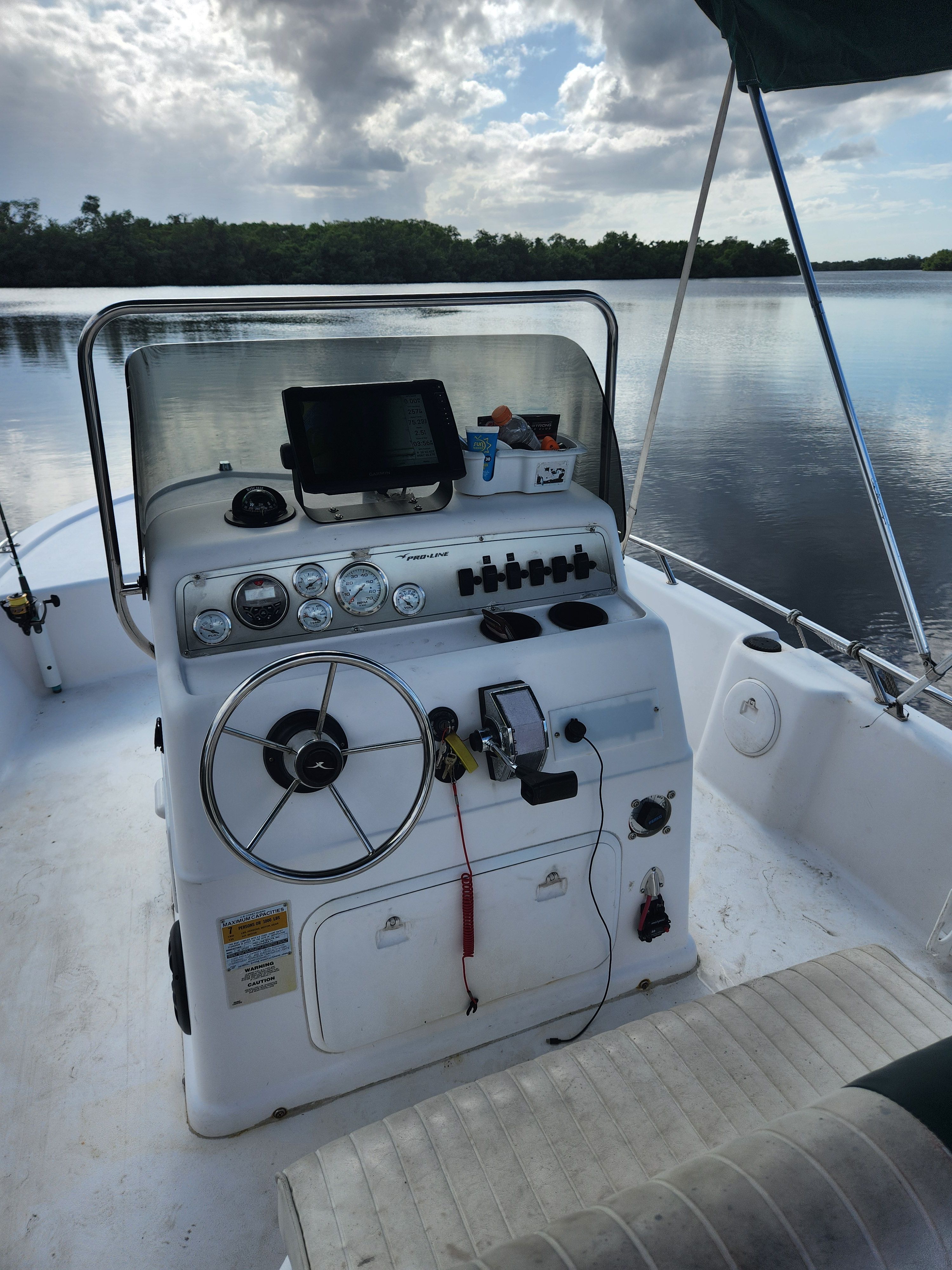 Pro-Line 18.8 Sport 2001 with helm console, on calm water under a cloudy sky.