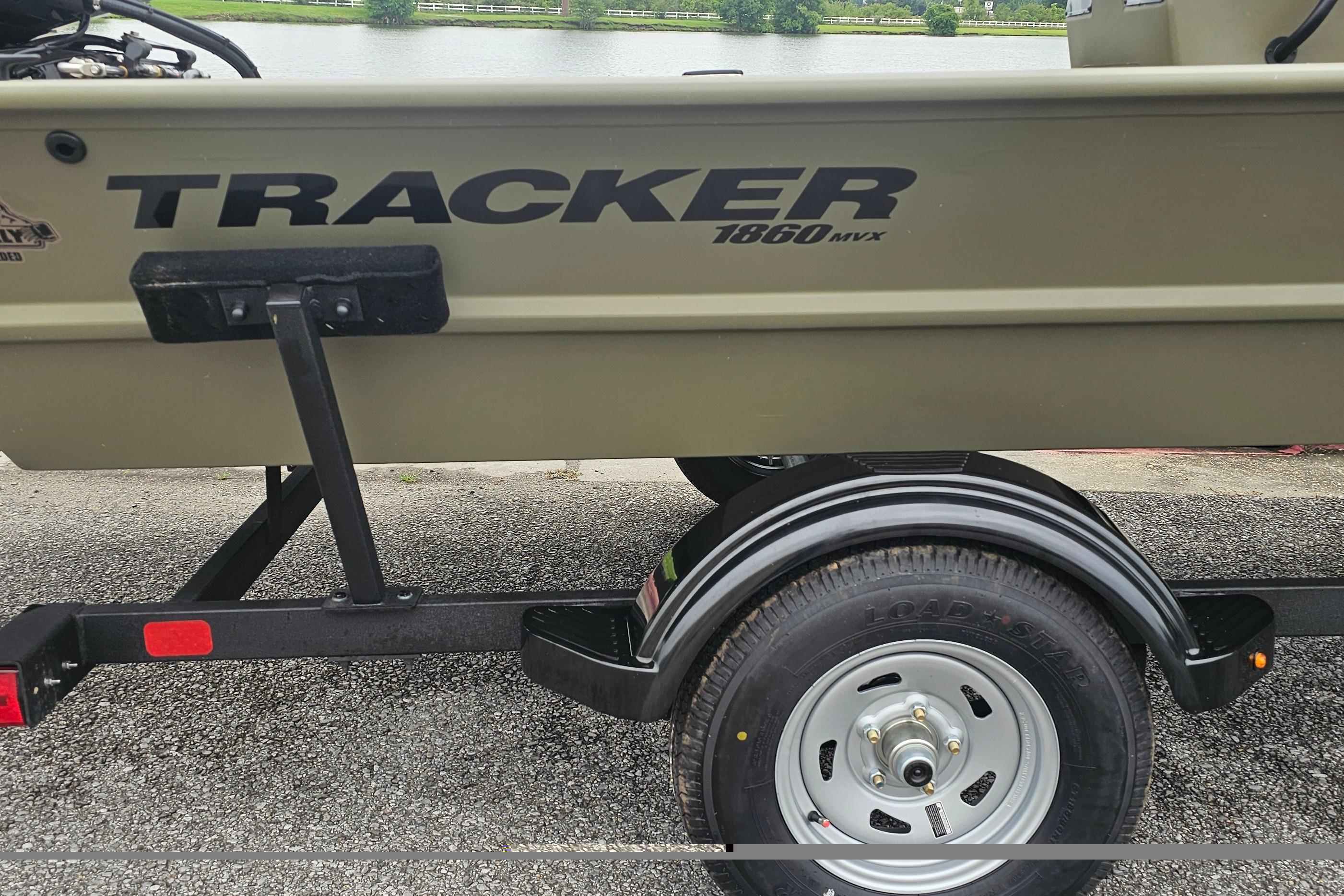 2026 Tracker Grizzly 1860 CC boat on trailer by a lake.