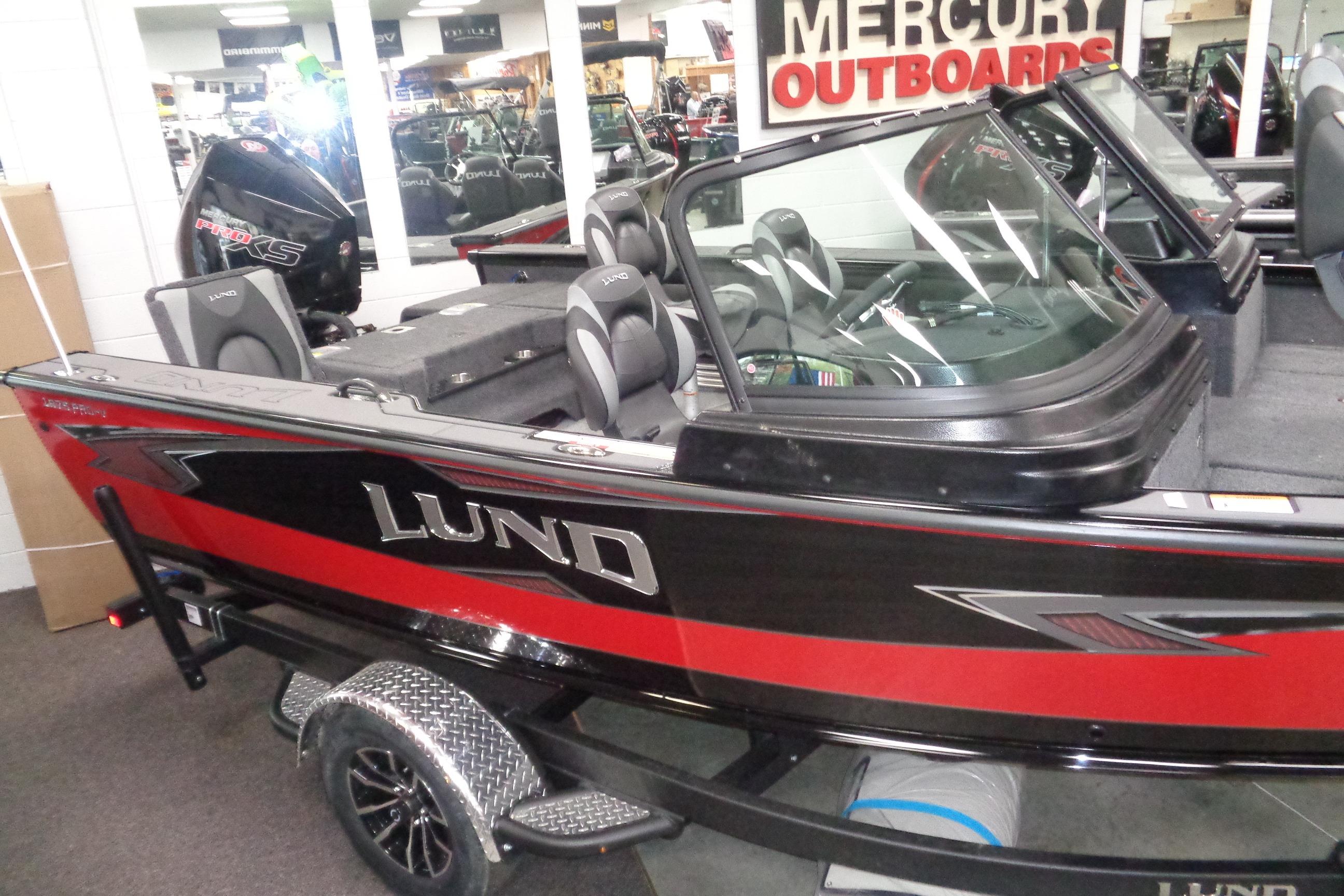 2026 Lund 1875 Pro-V boat displayed indoors, featuring sleek design and Mercury outboard motor.