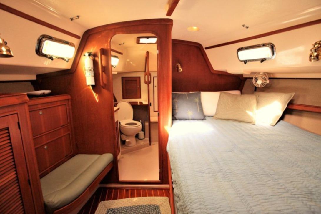Cozy cabin interior of 2000 Island Packet 420 yacht with bed and bathroom.