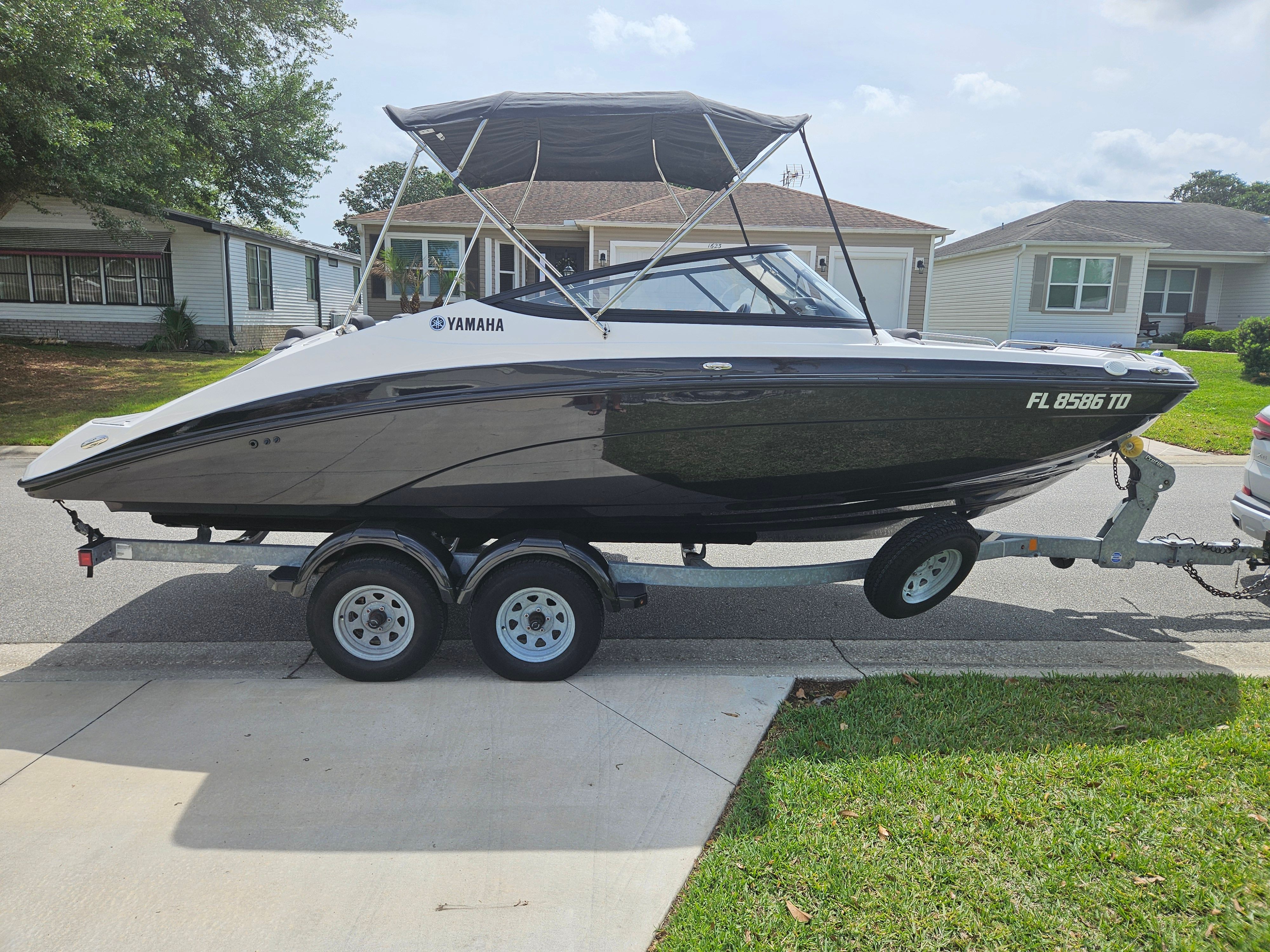 2022 Yamaha SX210 boat on trailer in residential area.