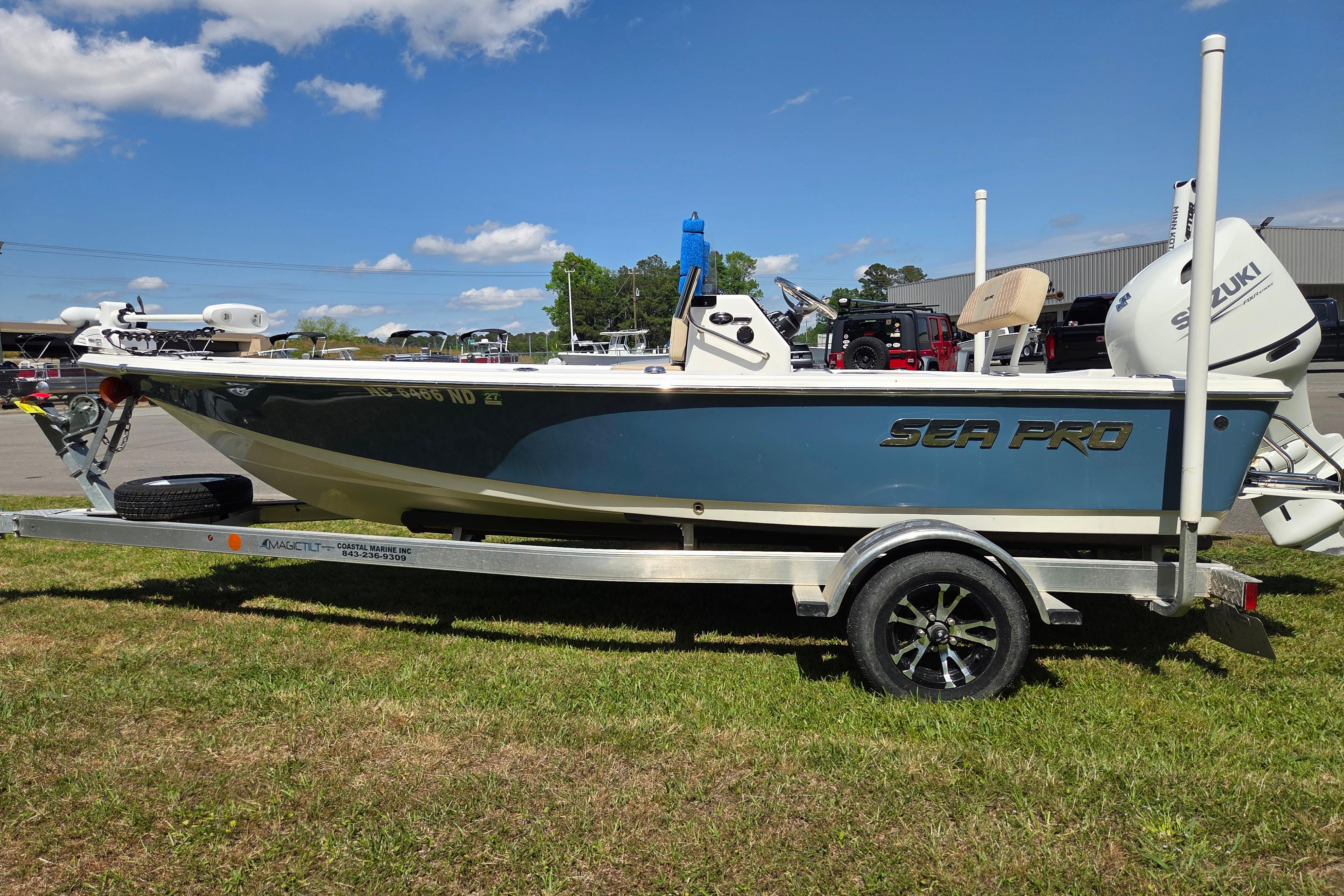 2024 Sea Pro 172 Bay boat on trailer, parked outdoors under a clear blue sky.