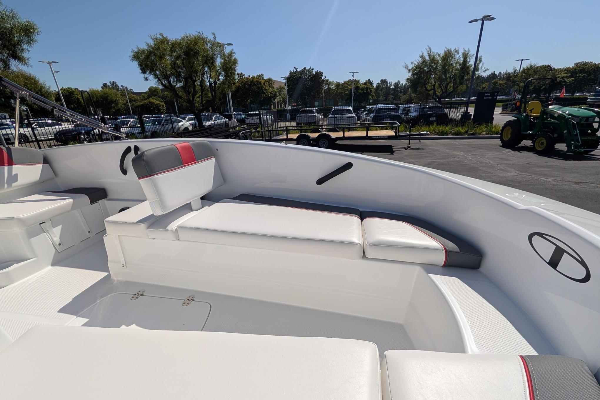 2026 Tahoe T16 boat interior with white and red seating, parked outdoors.