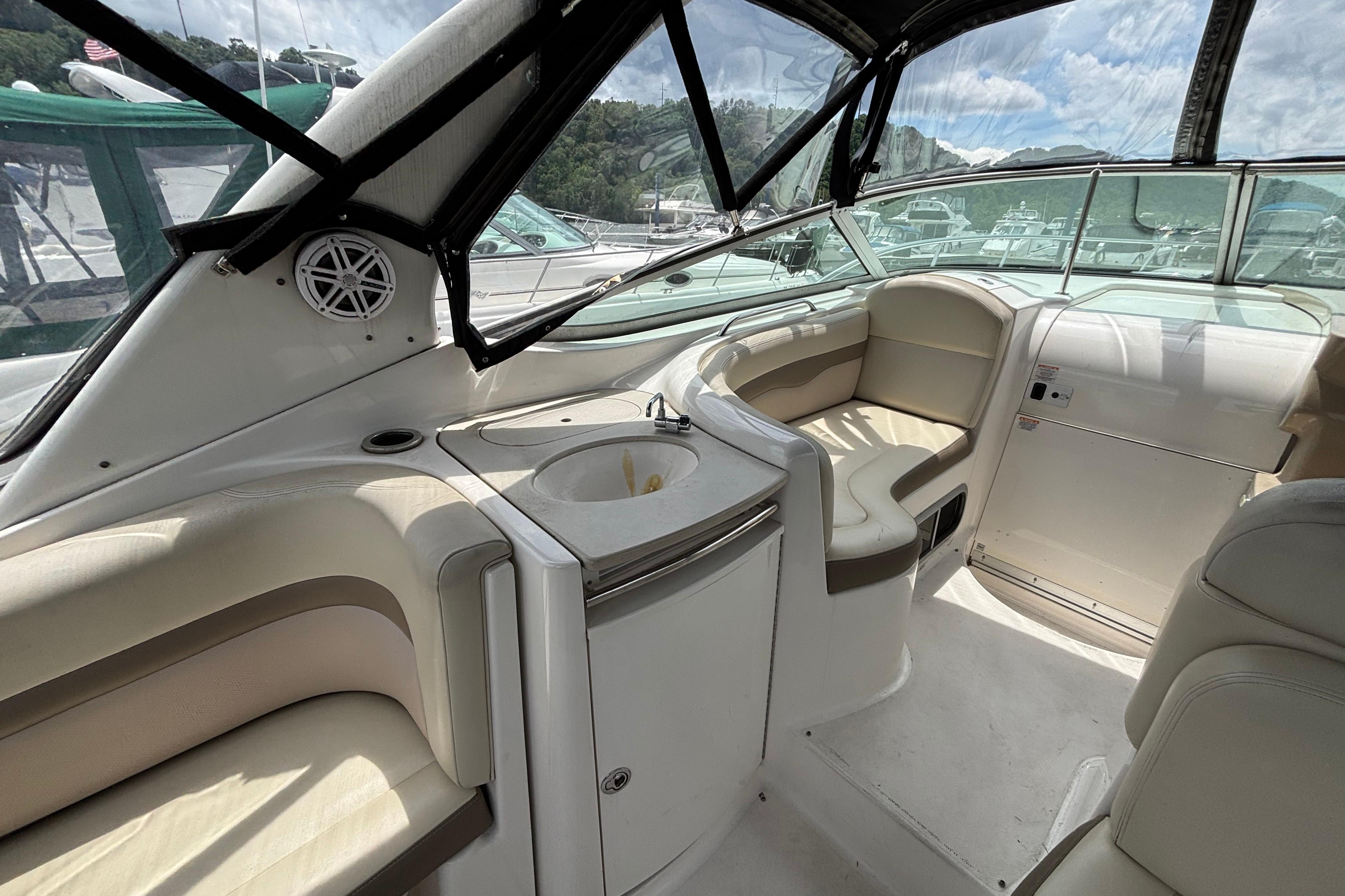 2004 Chaparral Signature 330 boat interior with seating and sink, under a clear canopy.