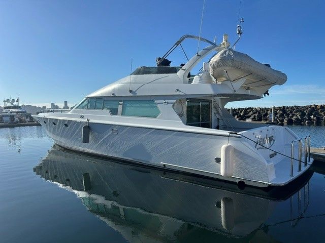 1990 custom motor yacht docked on calm water.