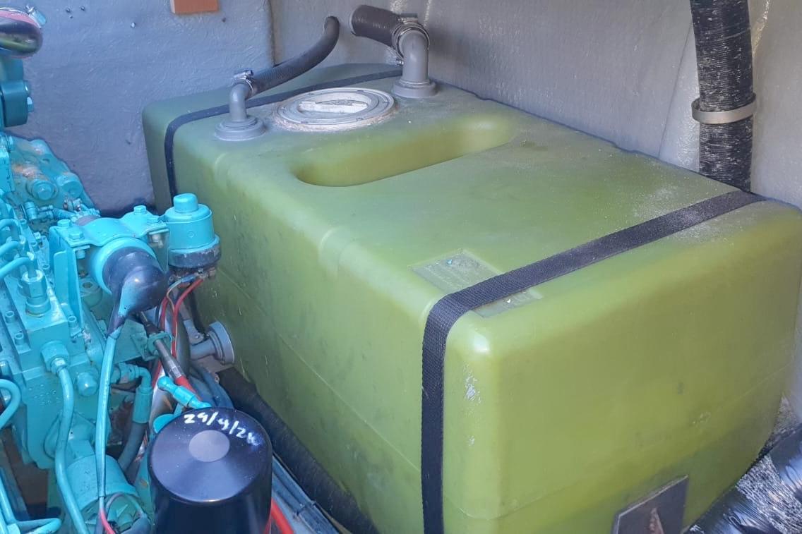 Engine compartment of 1989 Fairey Spearfish MKIII with green fuel tank and blue engine components.