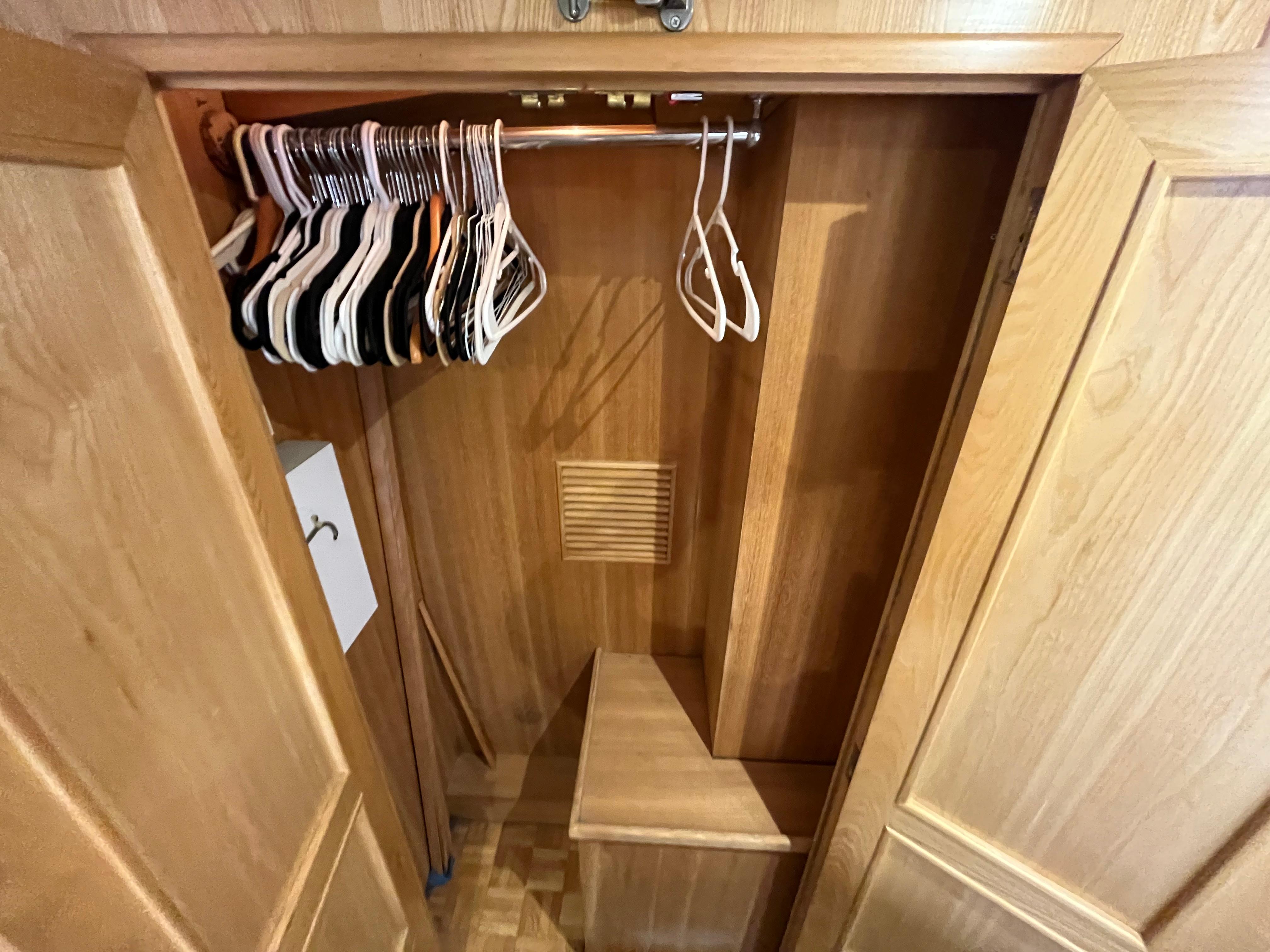 Wooden closet interior with hangers, part of a 1999 Ocean Alexander Sundeck 460 yacht.