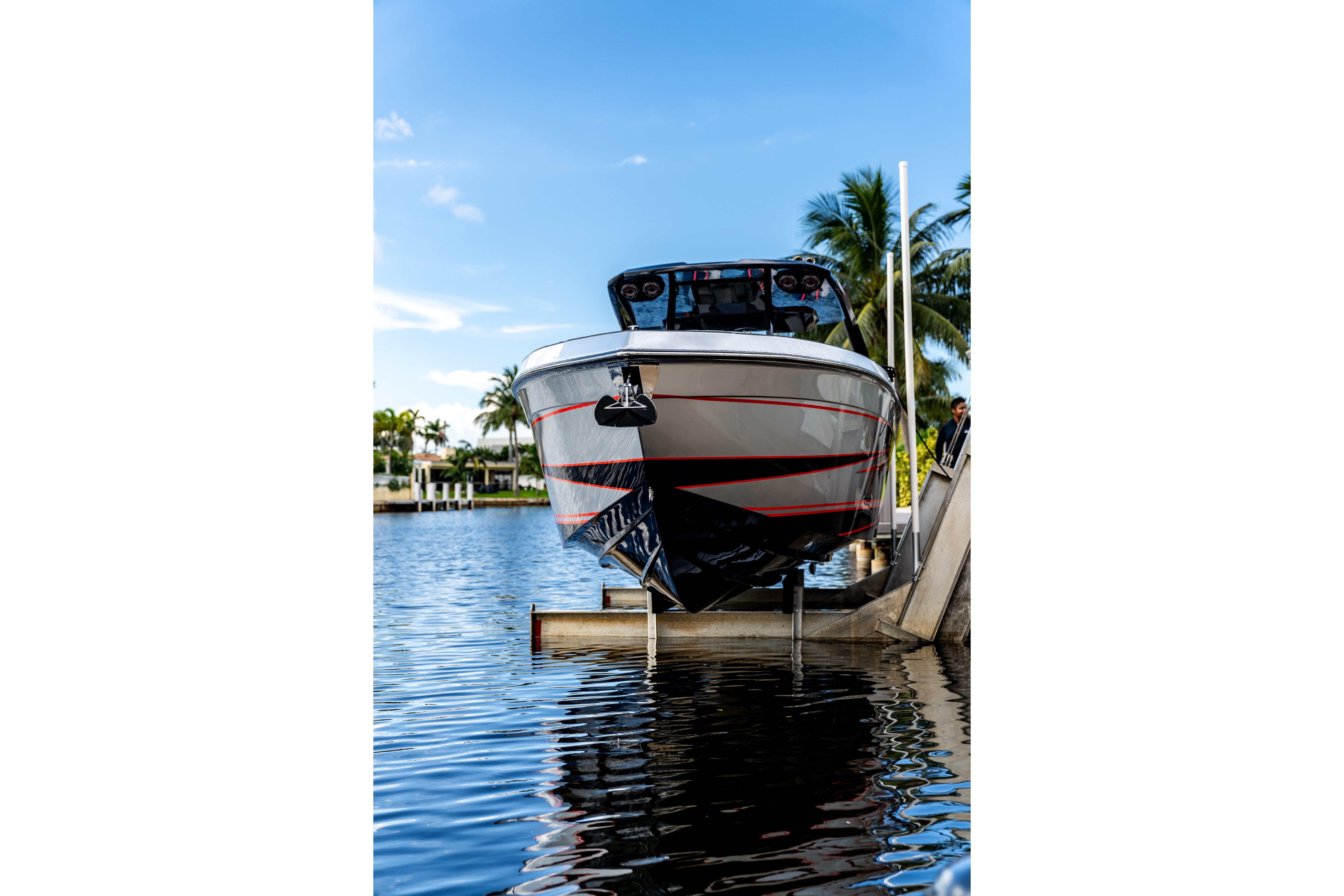 AMP 333 boat from 2026 on a lift by the water, with palm trees.