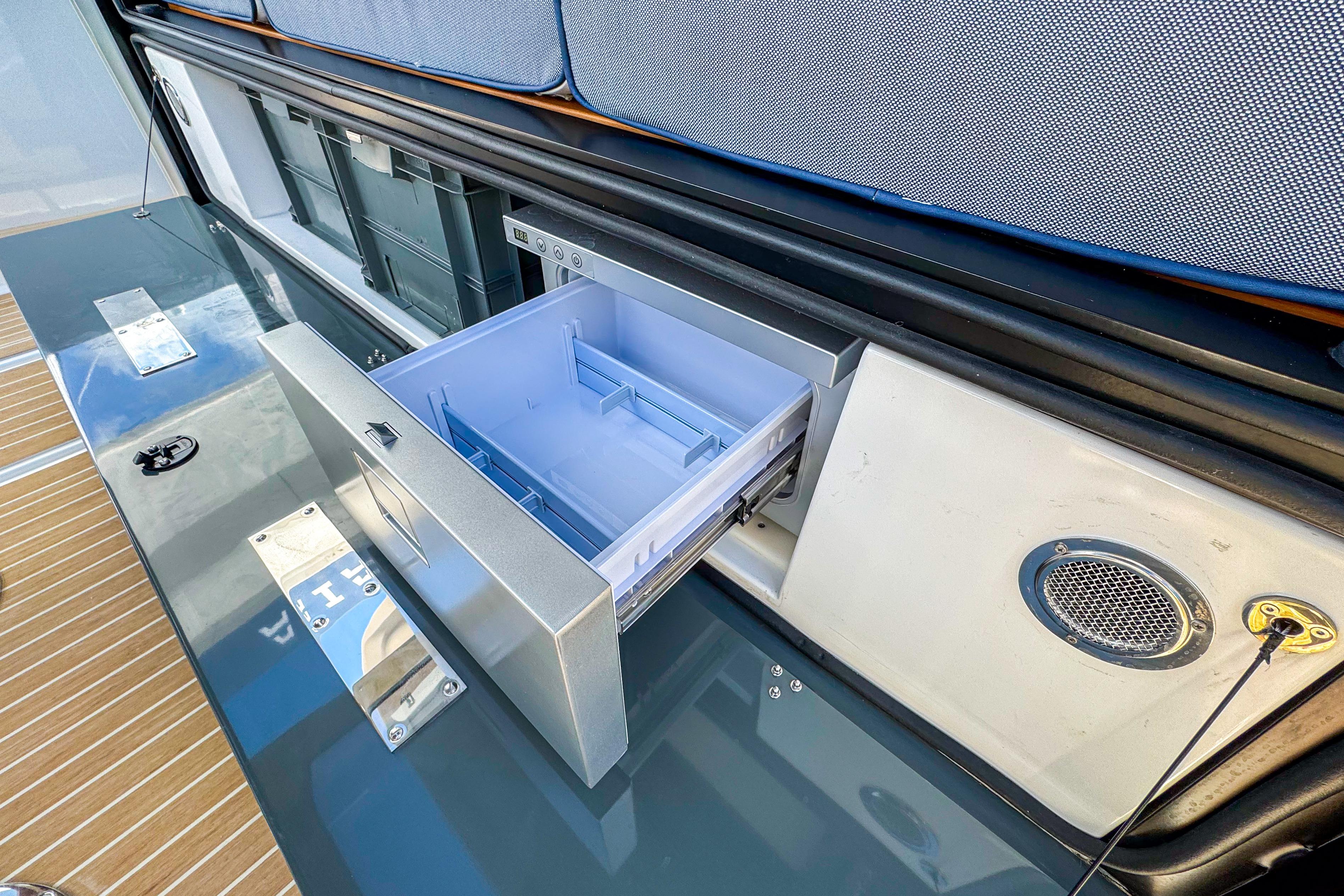 Open storage compartment on 2025 Aiata Wayfinder 38 Cabin boat, showcasing sleek design.
