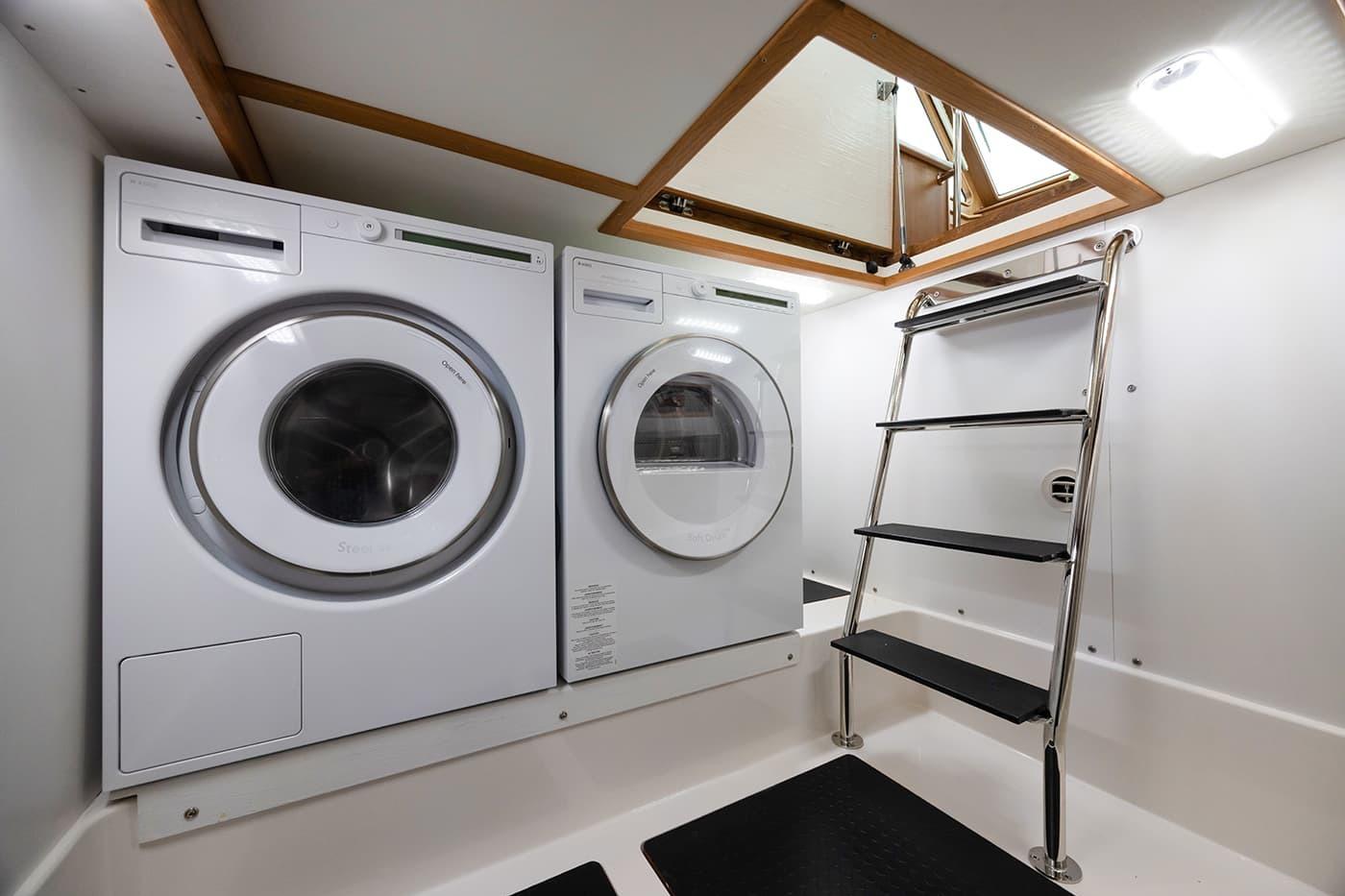 Laundry area with washer, dryer, and ladder in 2026 Sabre 45 Salon Express yacht.