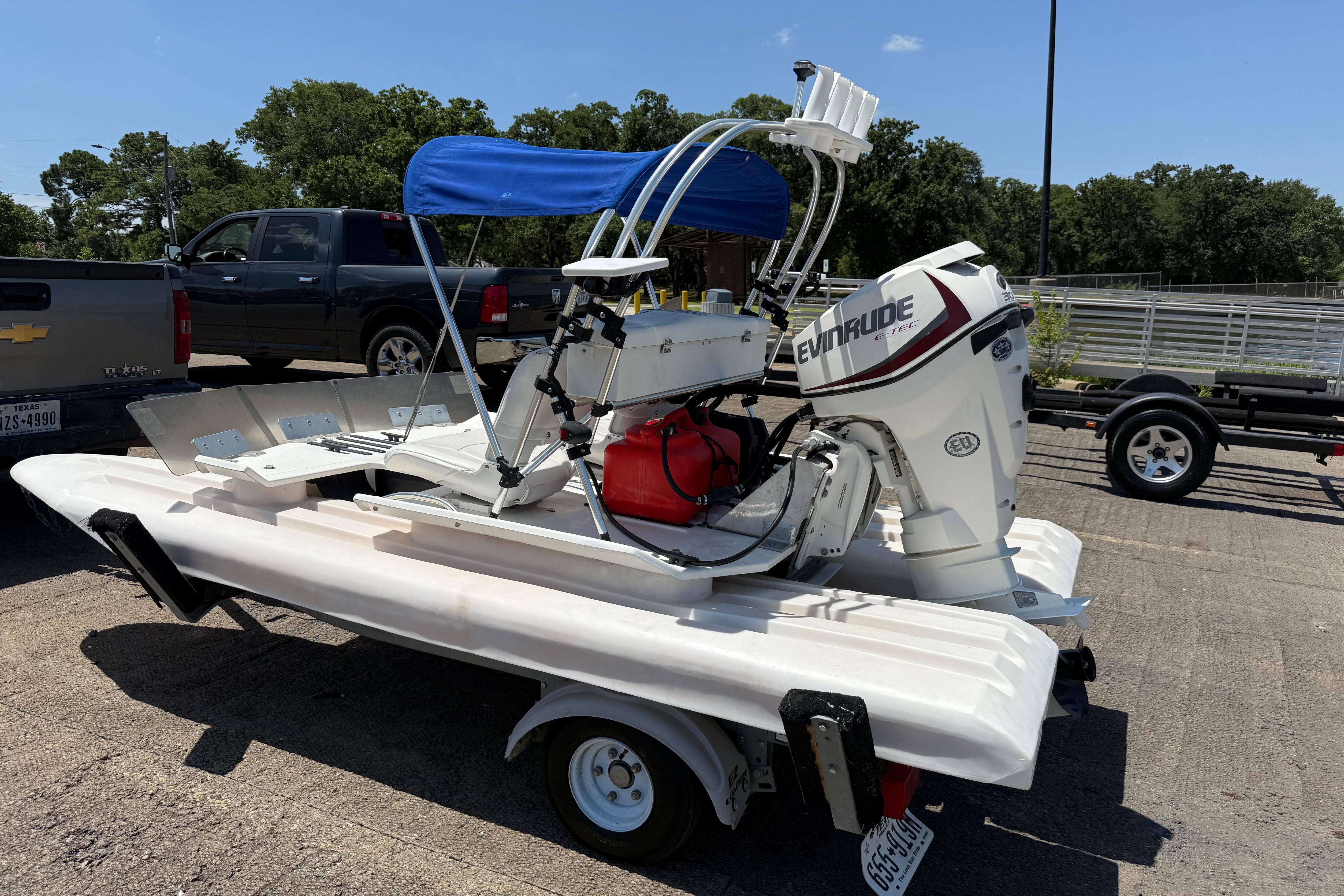 2016 CraigCat E2 Elite boat with Evinrude motor on trailer, parked outdoors.