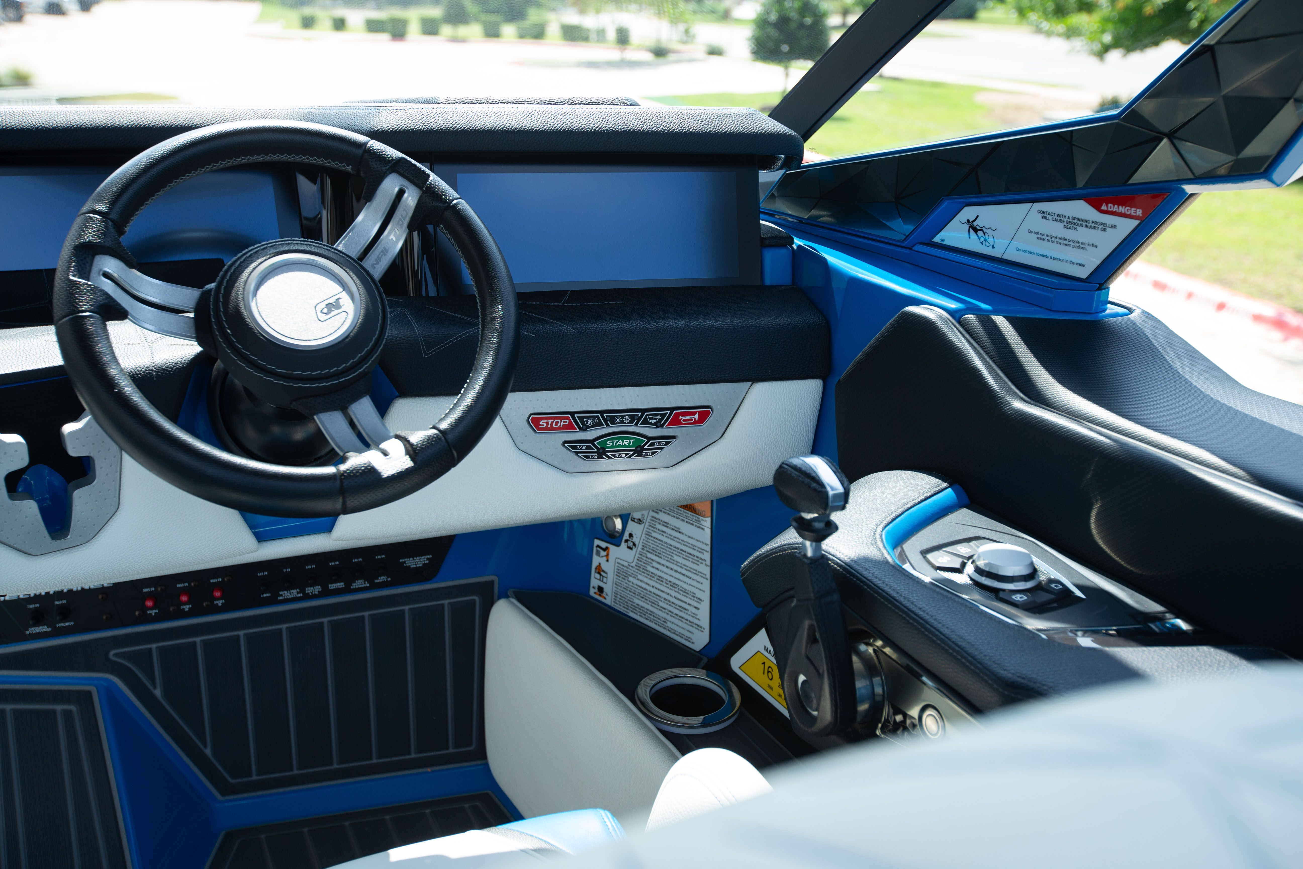 The cockpit of a modern boat with a steering wheel and control console.