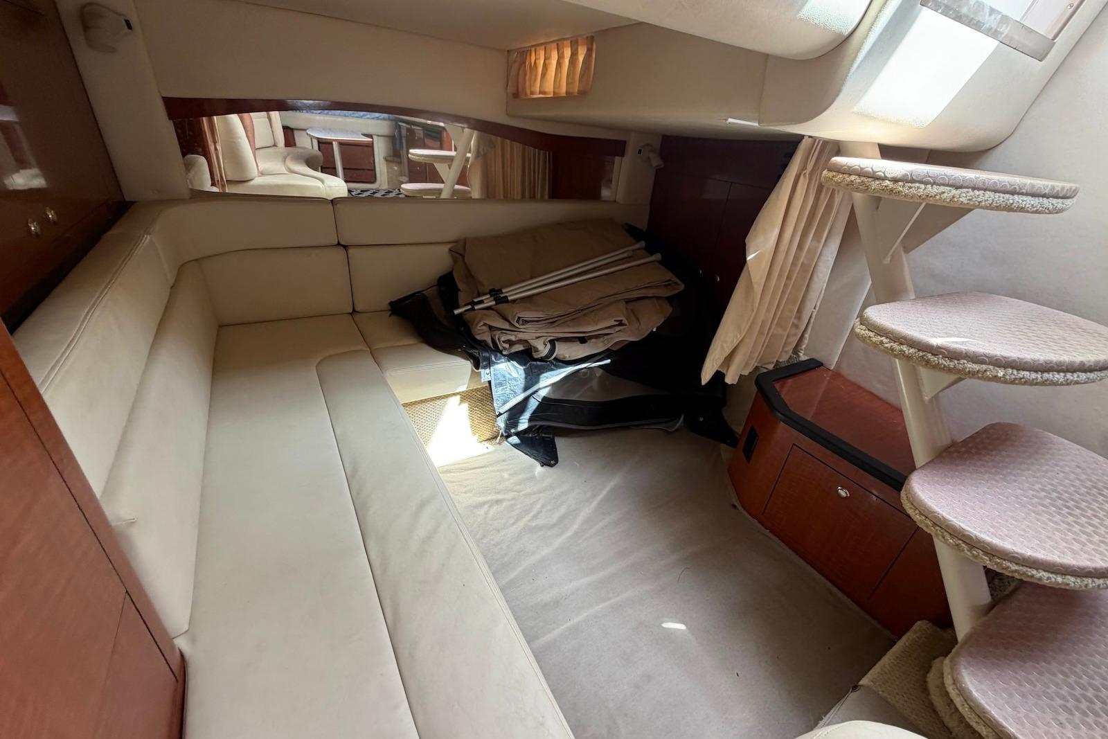 Interior cabin of 2003 Sea Ray 340 Sundancer with beige seating and carpeted stairs.