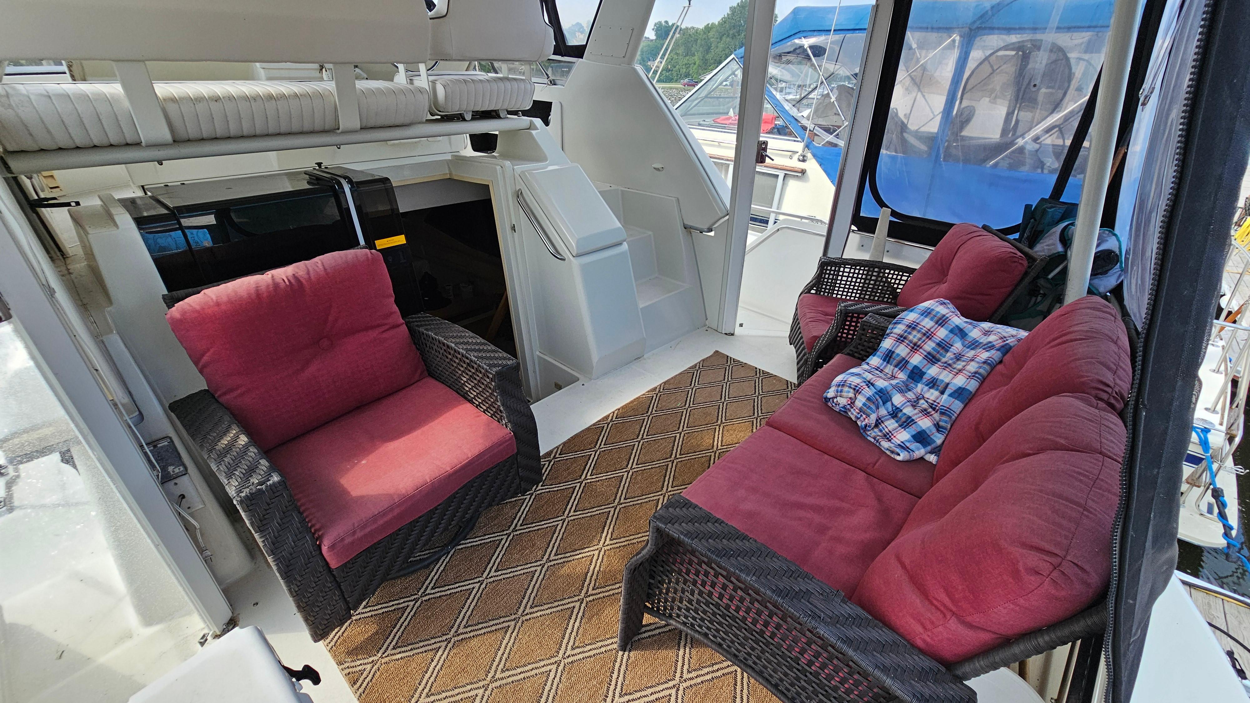 1995 Carver 355 Aft Cabin interior with red cushioned seating and patterned rug.