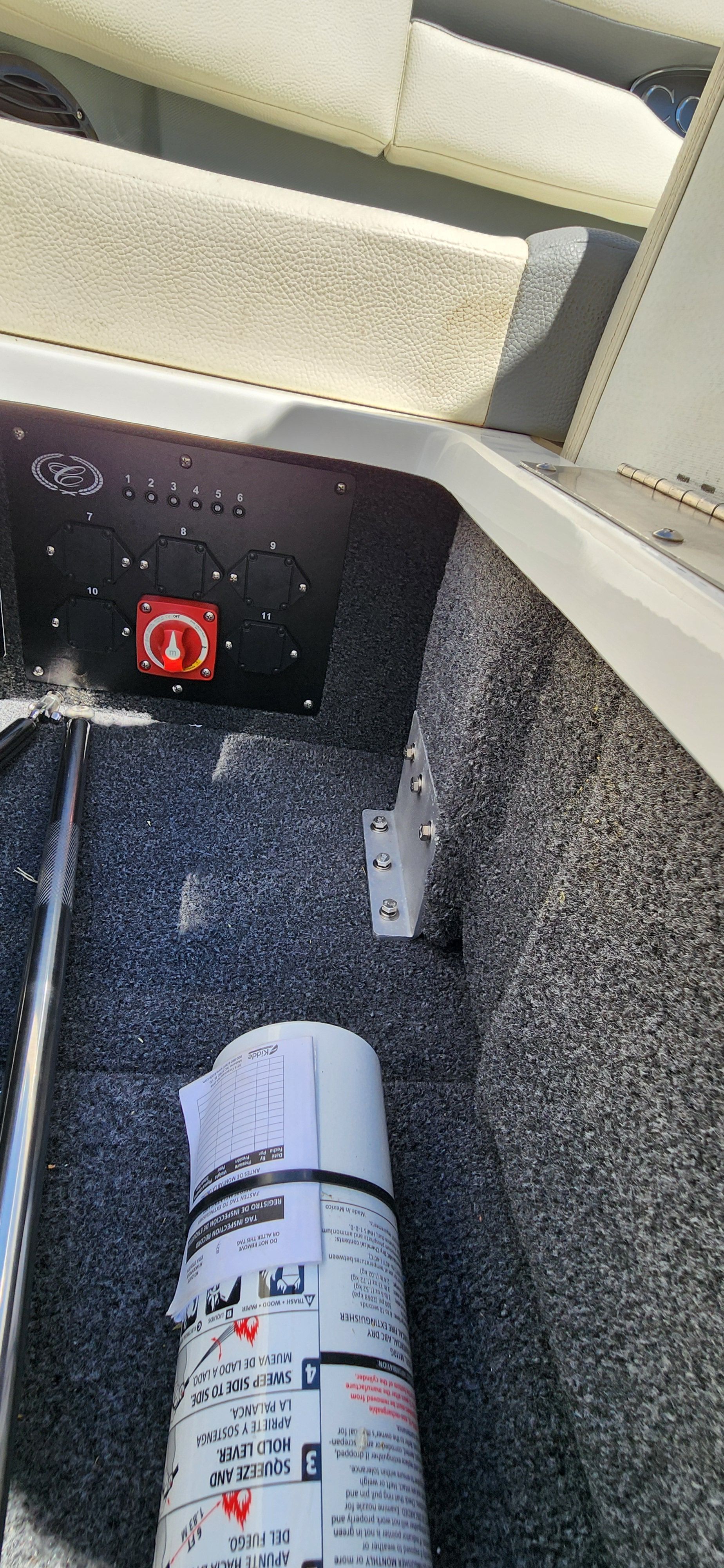 Interior of a Cobalt CS22 boat with a fire extinguisher and control panel.