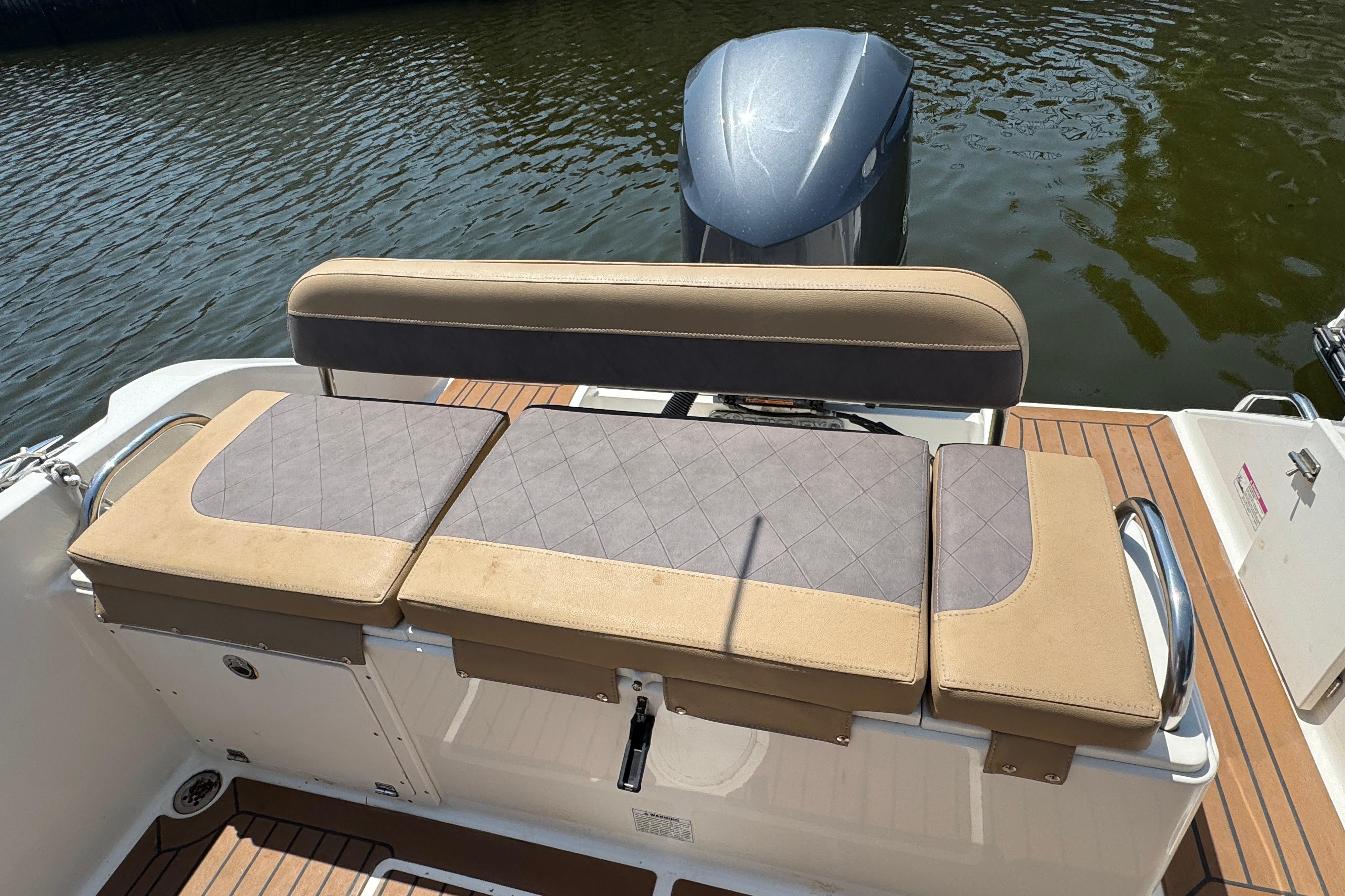 2014 Century 2301 Center Console boat with cushioned seating and outboard motor on water.