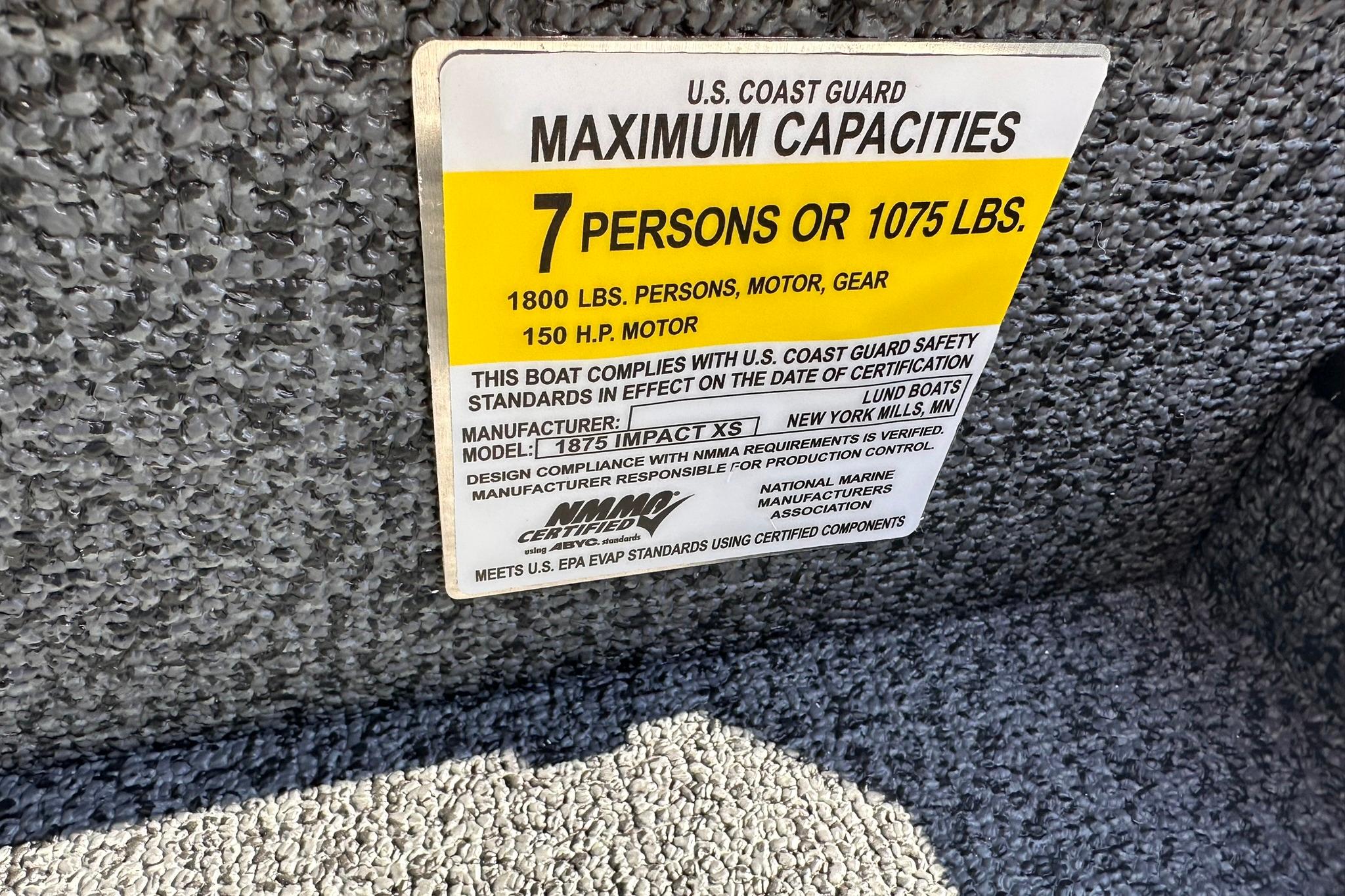 2026 Lund 1875 Impact XS SS boat capacity label, 7 persons or 1075 lbs, U.S. Coast Guard compliant.