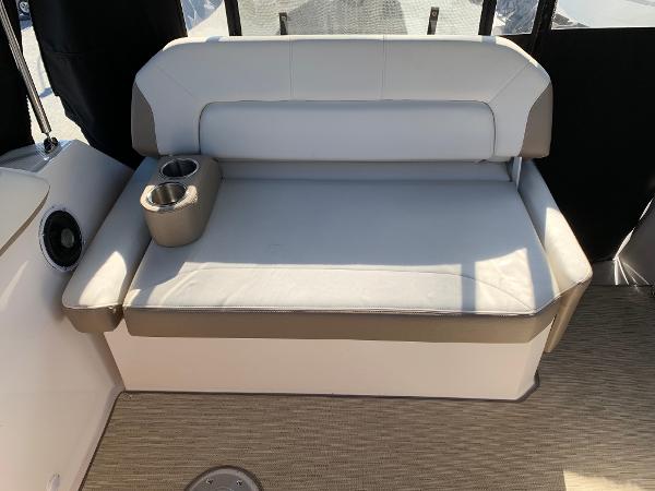 Seating area with gray upholstery and cup holders on a boat.