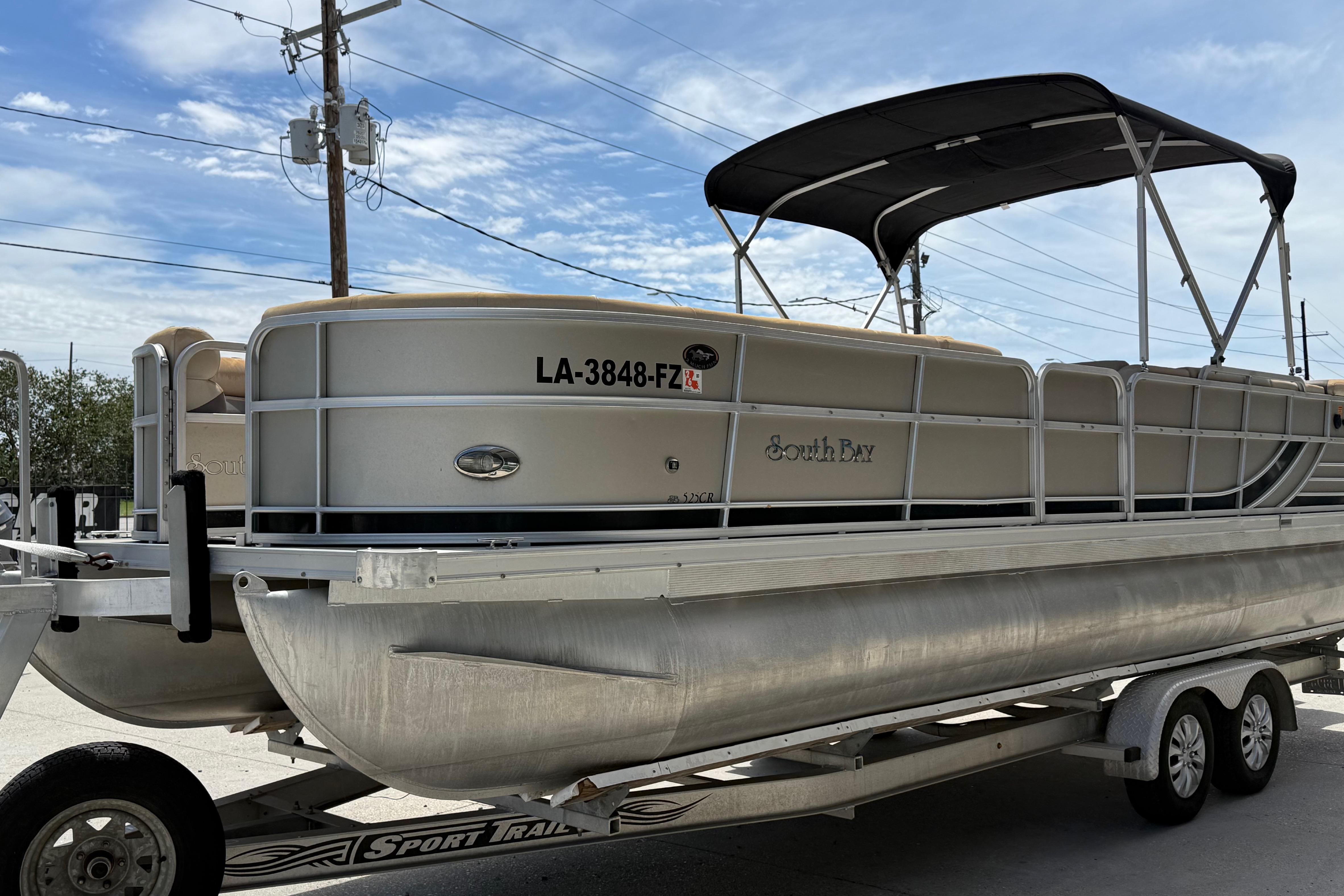 2012 South Bay 522 CR pontoon boat on trailer under blue sky.