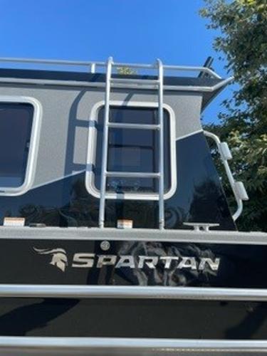 2025 Spartan 2600 Olympia boat with ladder and logo, under clear blue sky.