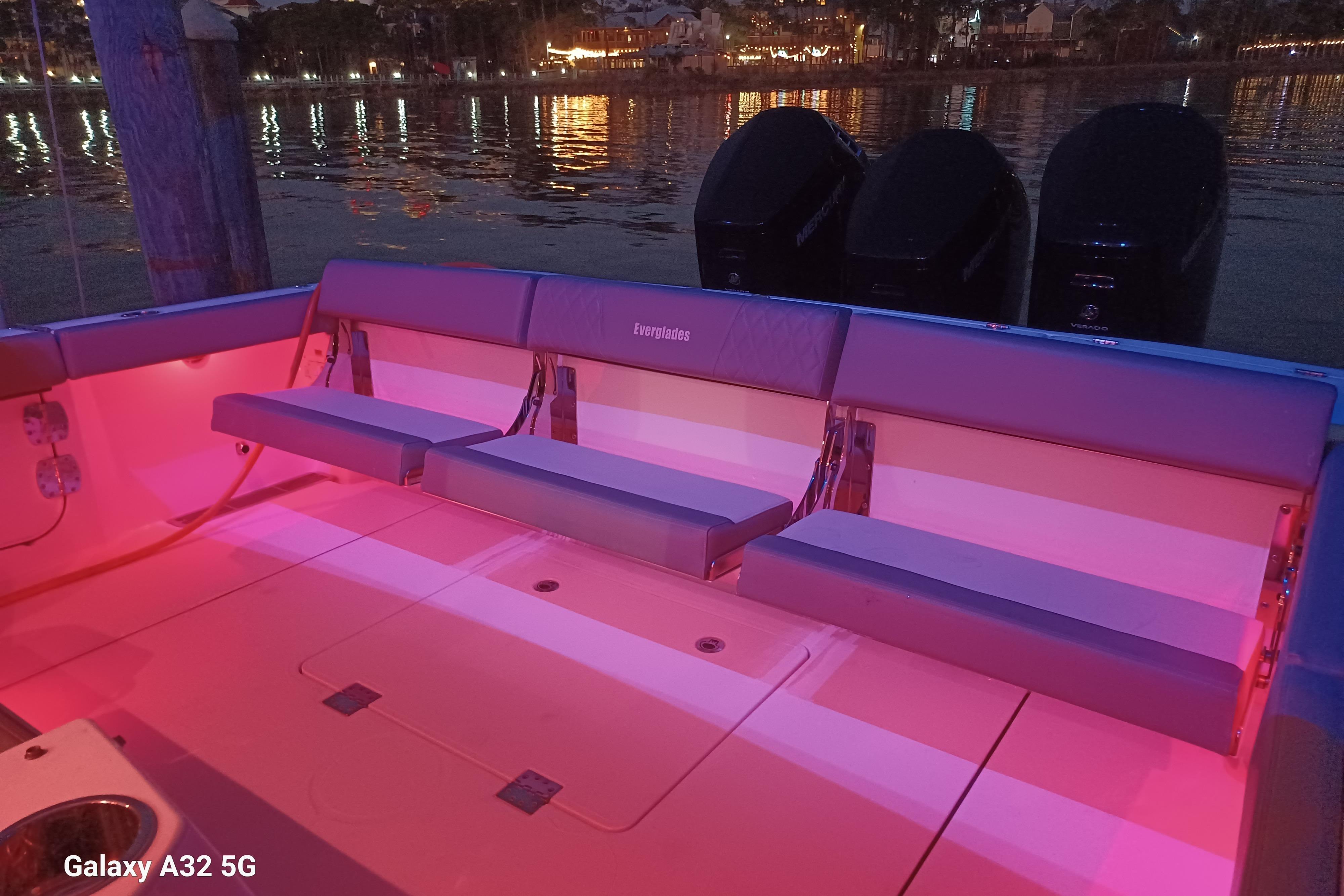 2024 Everglades 455 Center Console boat with illuminated seating and dual engines at night.