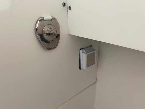 Close-up of a boat lock and switch on a white surface.