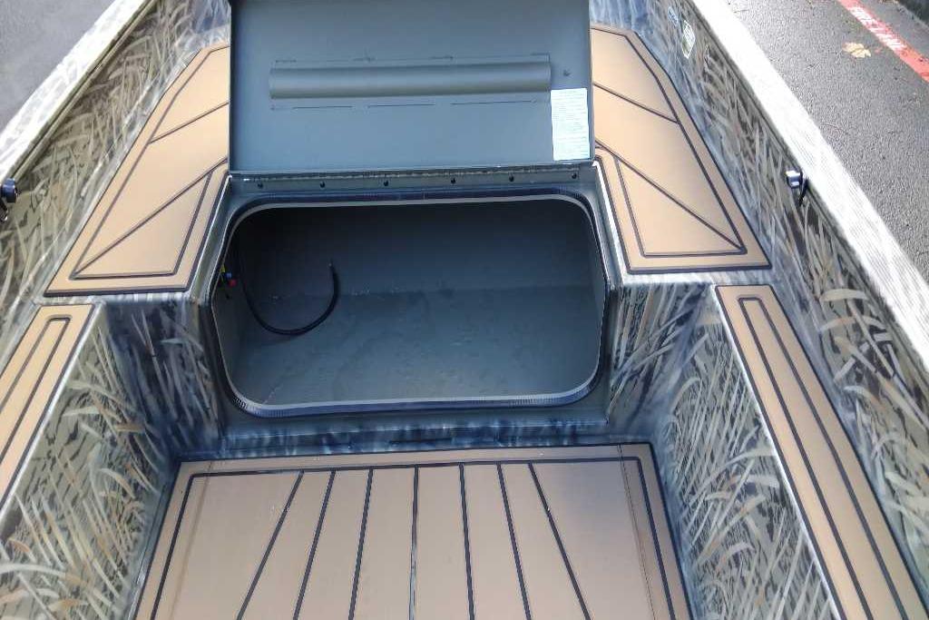 2026 Tracker Grizzly 1650 T Prairie Wings Edition boat interior with open storage compartment.