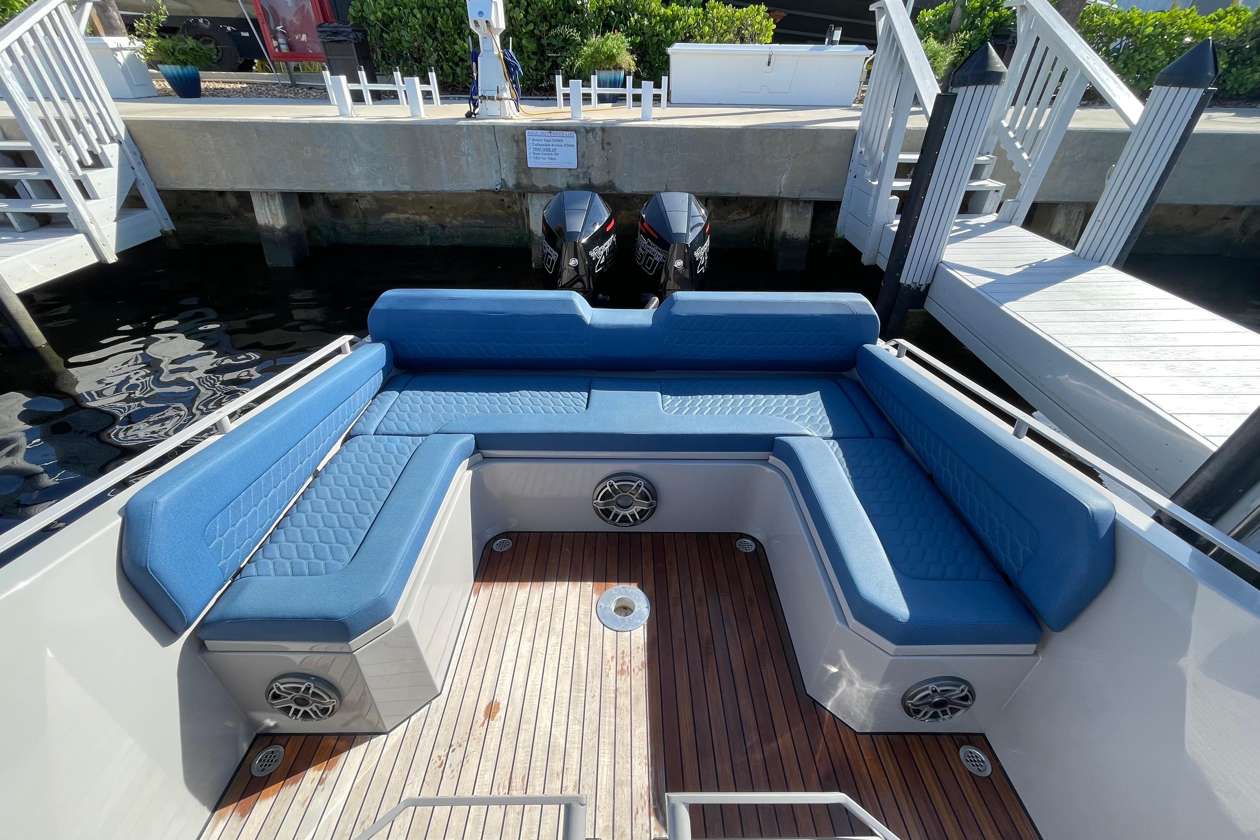 Luxurious seating area on 2023 Skipper-BSK BSK 38 boat with blue cushions and wooden deck.
