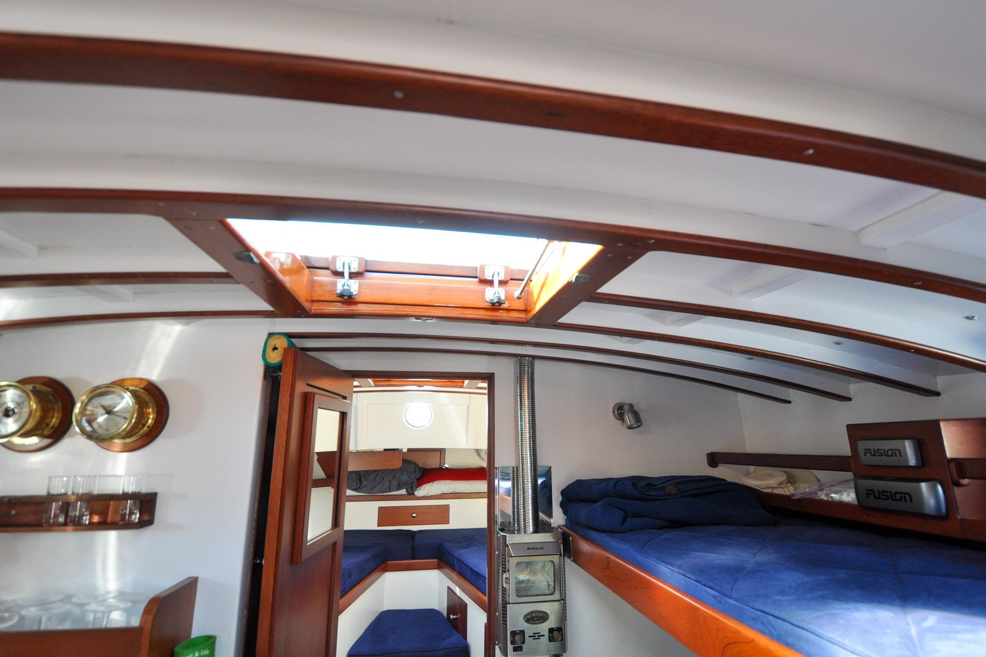 Interior of a 1958 Bunker and Ellis 42 boat with wooden accents and cozy sleeping area.