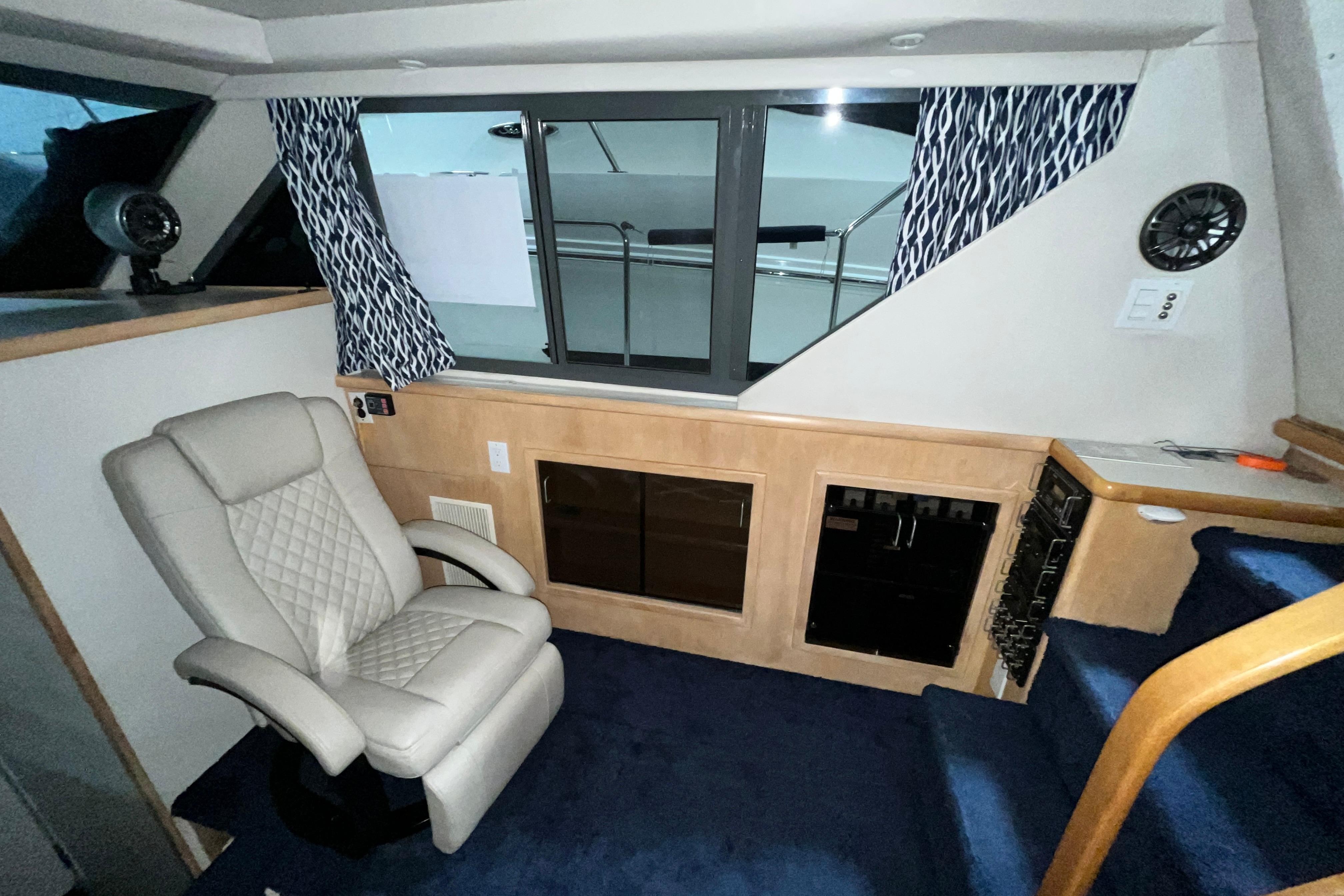 Interior of 1995 Carver 325 Aft Cabin Motor Yacht with chair and window view.