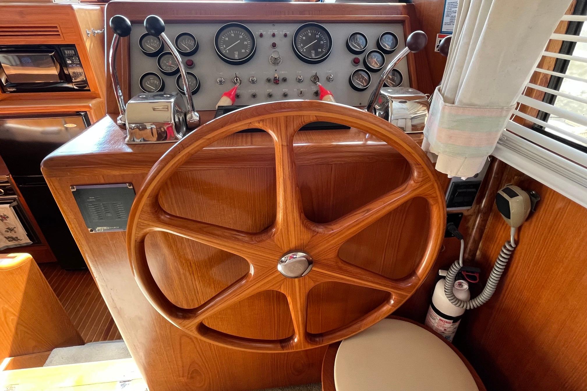 1989 Ocean Alexander 440 Sundeck CPMY helm with wooden wheel and control panel.