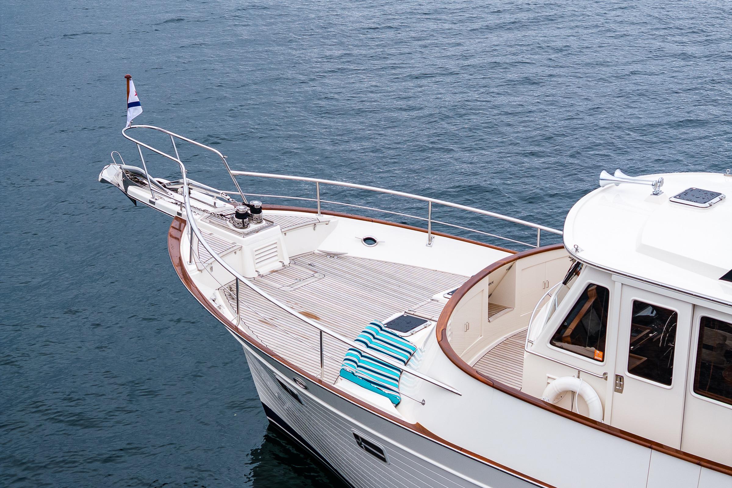 2026 Fleming 55 Pilothouse yacht on calm water, featuring a sleek deck and pilothouse.