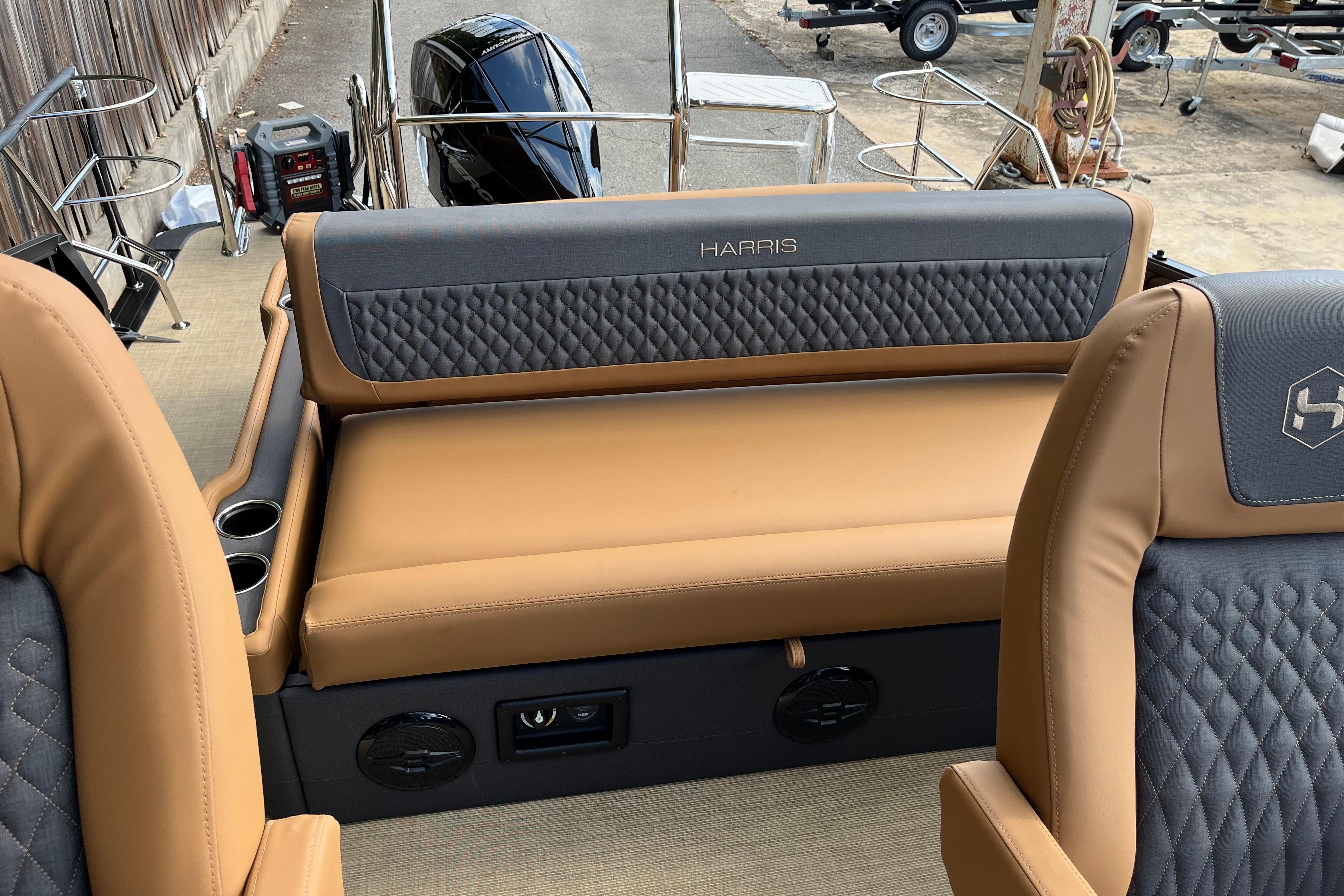2025 Harris Sunliner 250 boat interior with tan and gray seating, cup holders, and modern design.