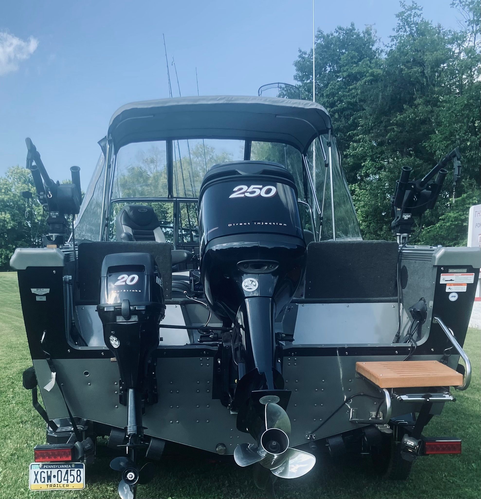 A 2012 Lund Baron boat with two outboard motors on a grassy area.