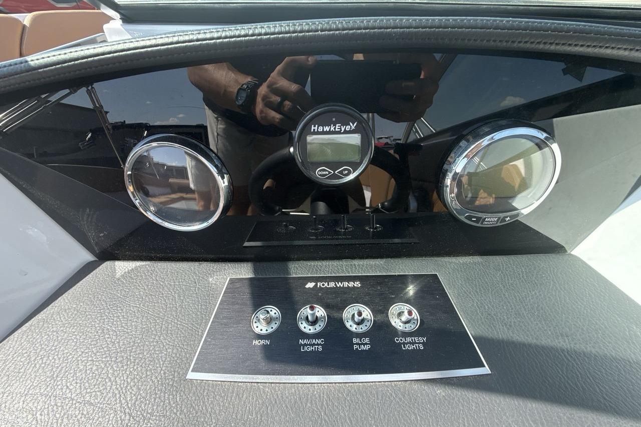 2024 Four Winns H1 OB dashboard with HawkEye display and control switches.