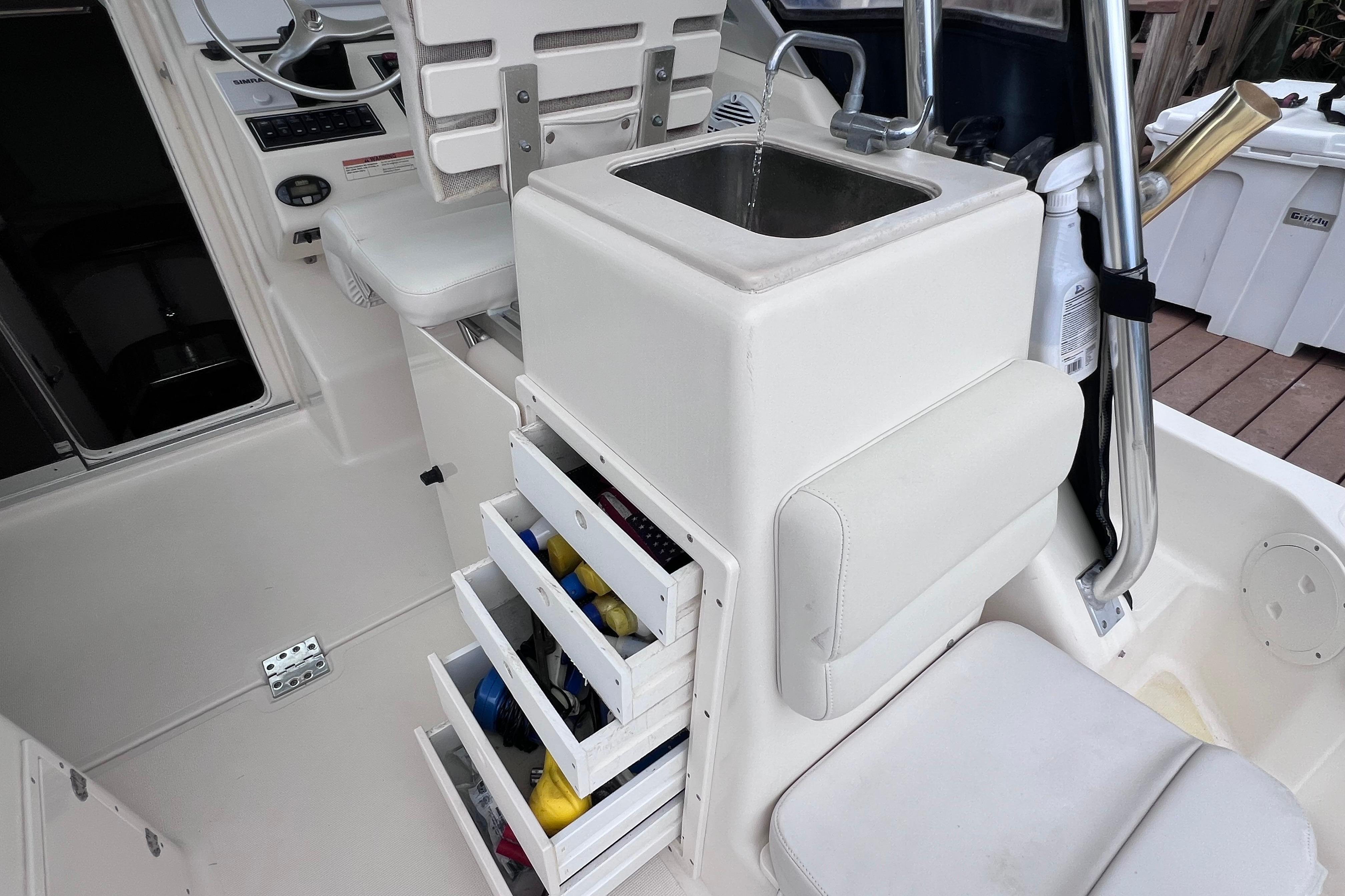 2005 Pursuit 3070 Offshore boat interior with sink and storage drawers.